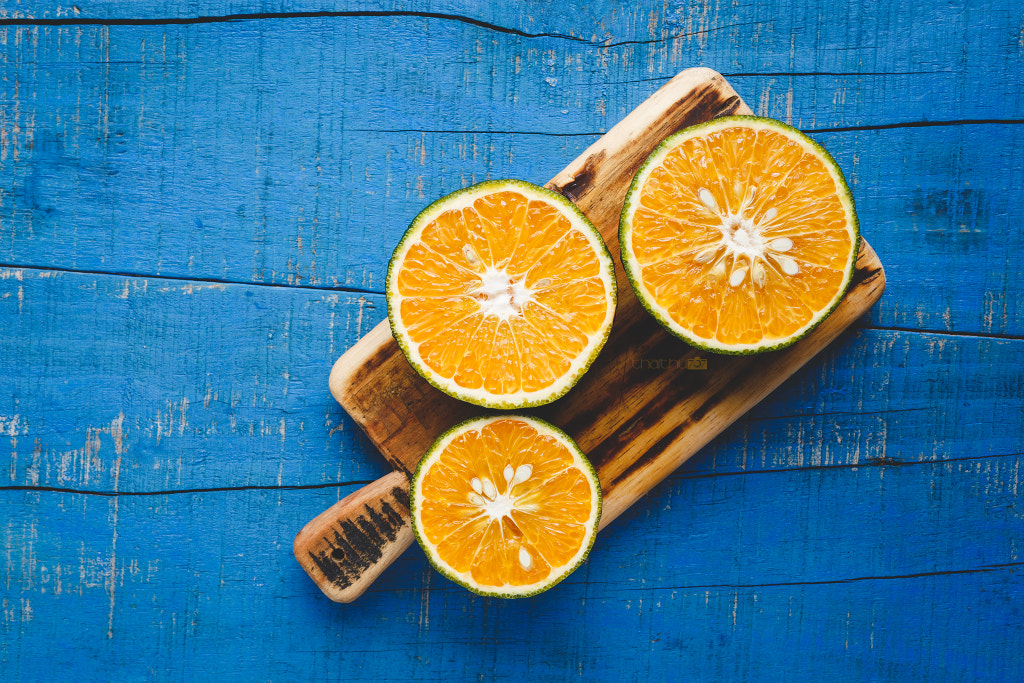 Orange slices on the blue wood background by Thai Thu on 500px.com