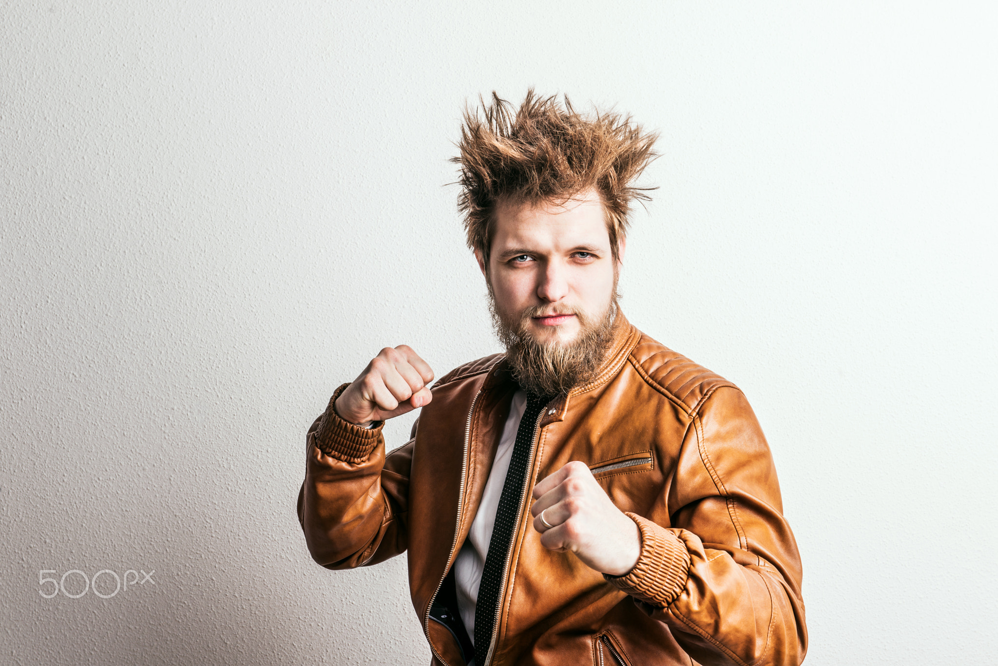 Portrait of a young angry hipster man in a studio. Copy space.