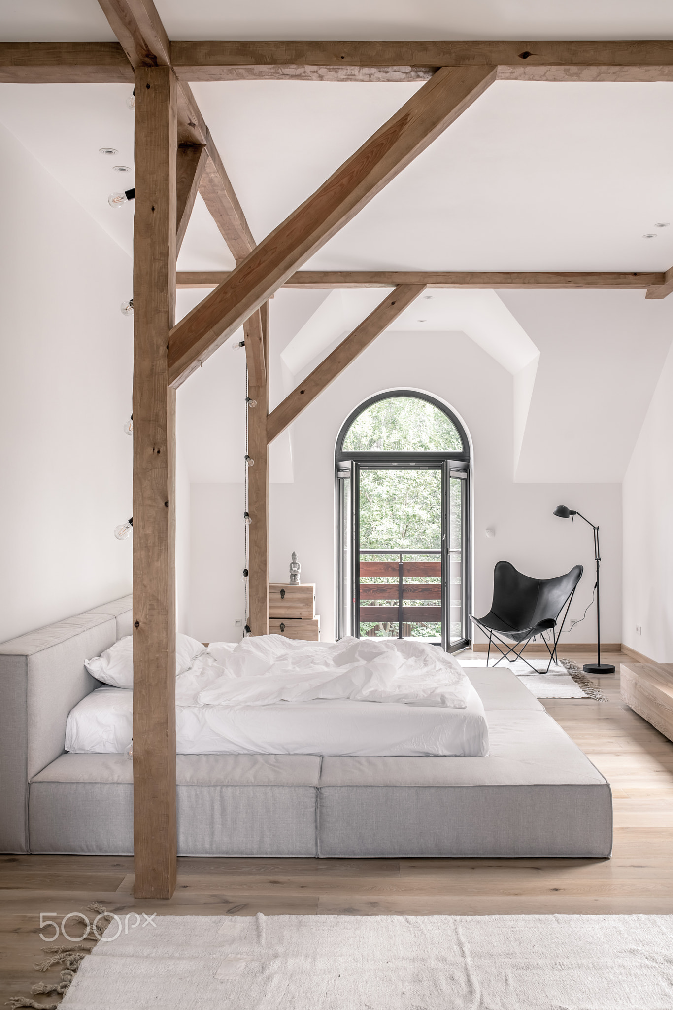 Stylish bedroom in modern style with wooden beams