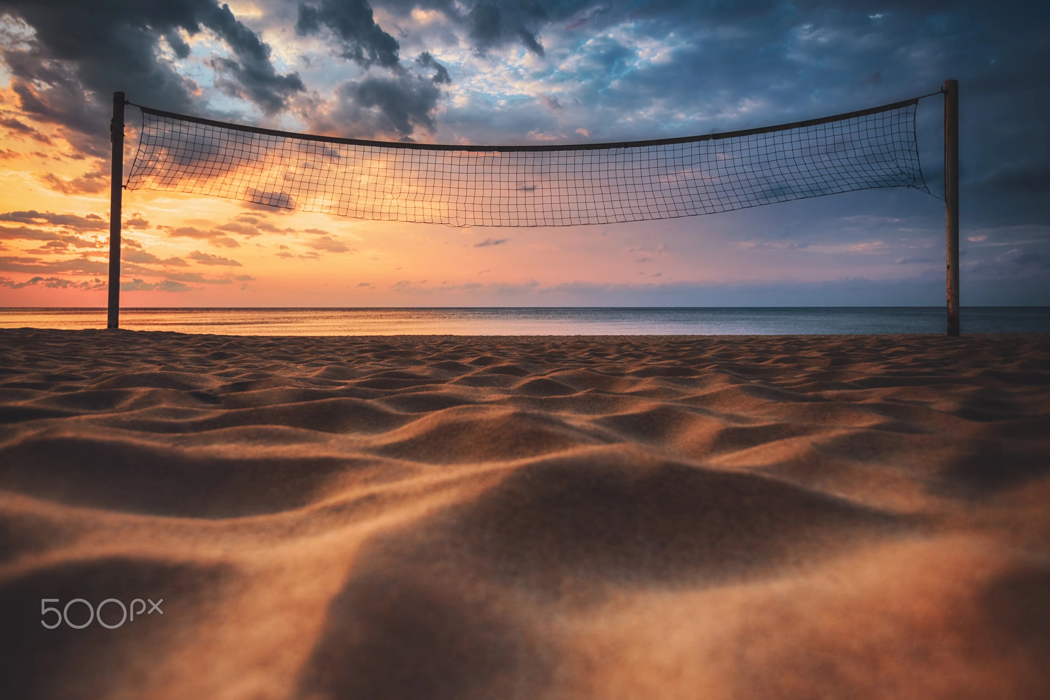 Volleyball net and sunrise on the beach