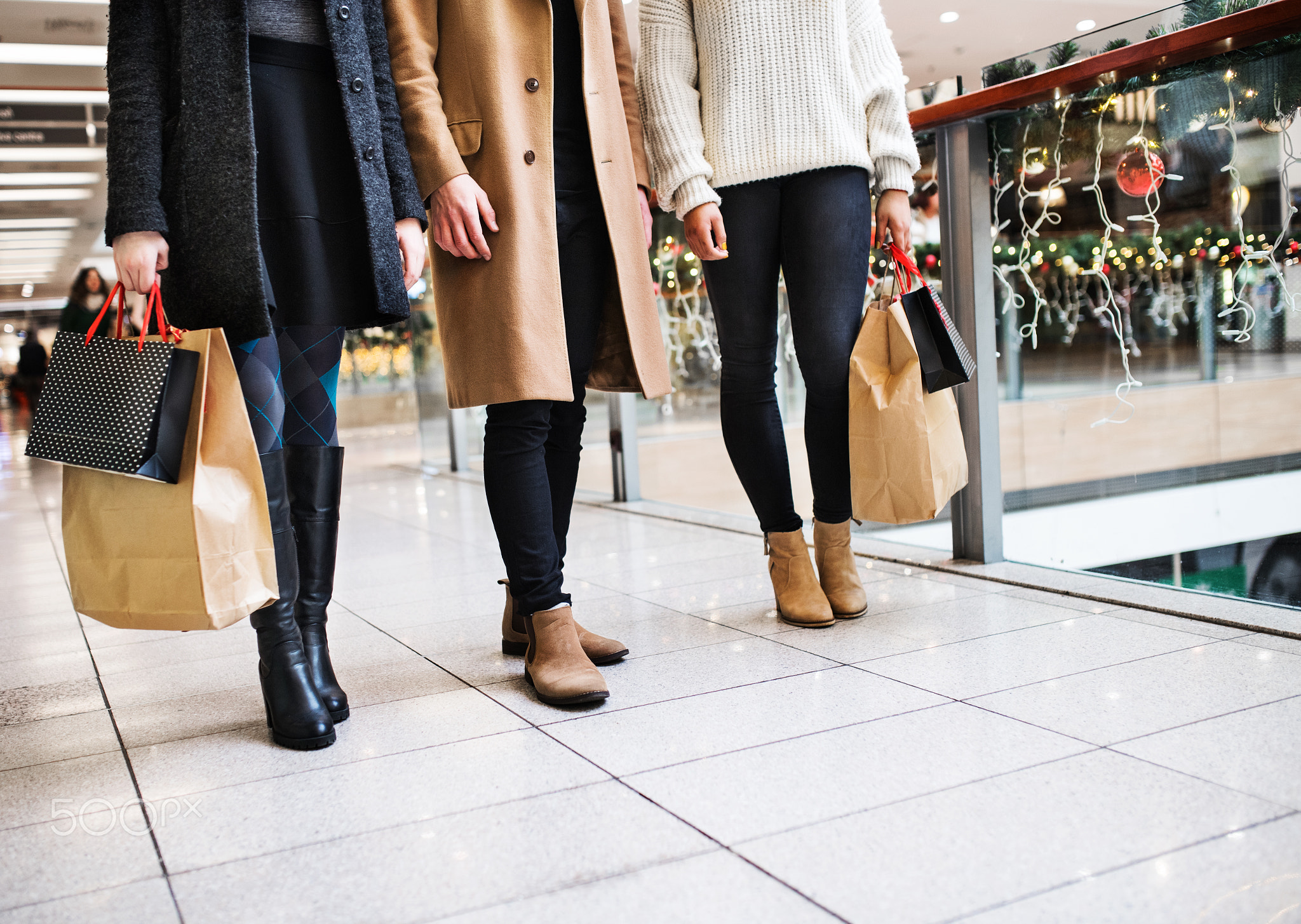 Young friends standing in shopping center at Christmas time.