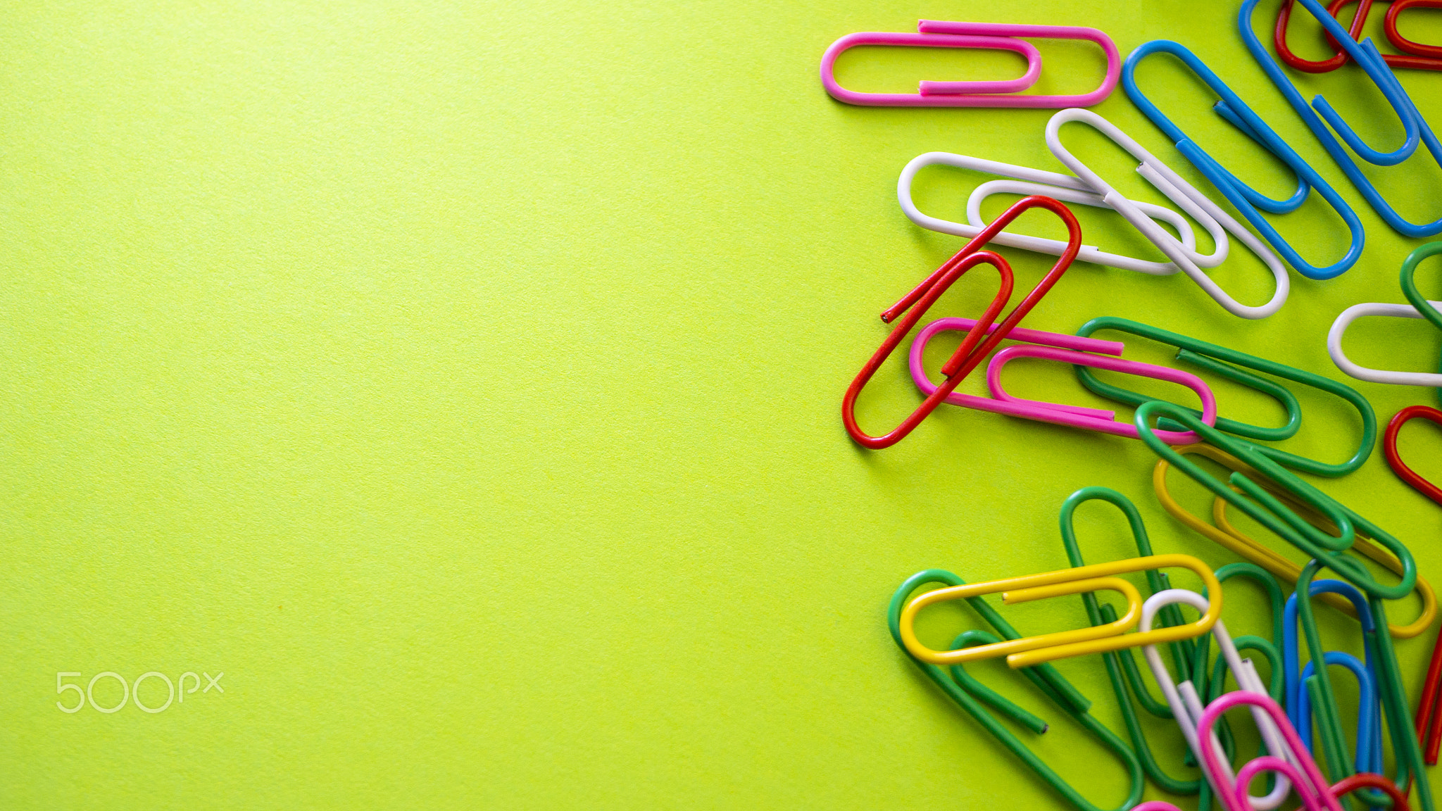 Color push pins on green background for copyspace