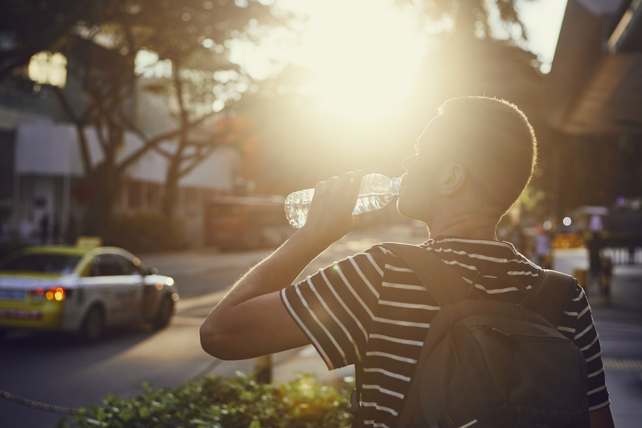 Man drinking water at sunset
