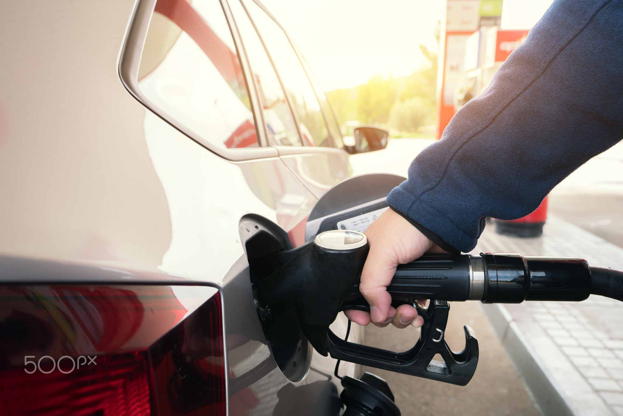 Car refueling on petrol station. Man pumping gasoline oil. This