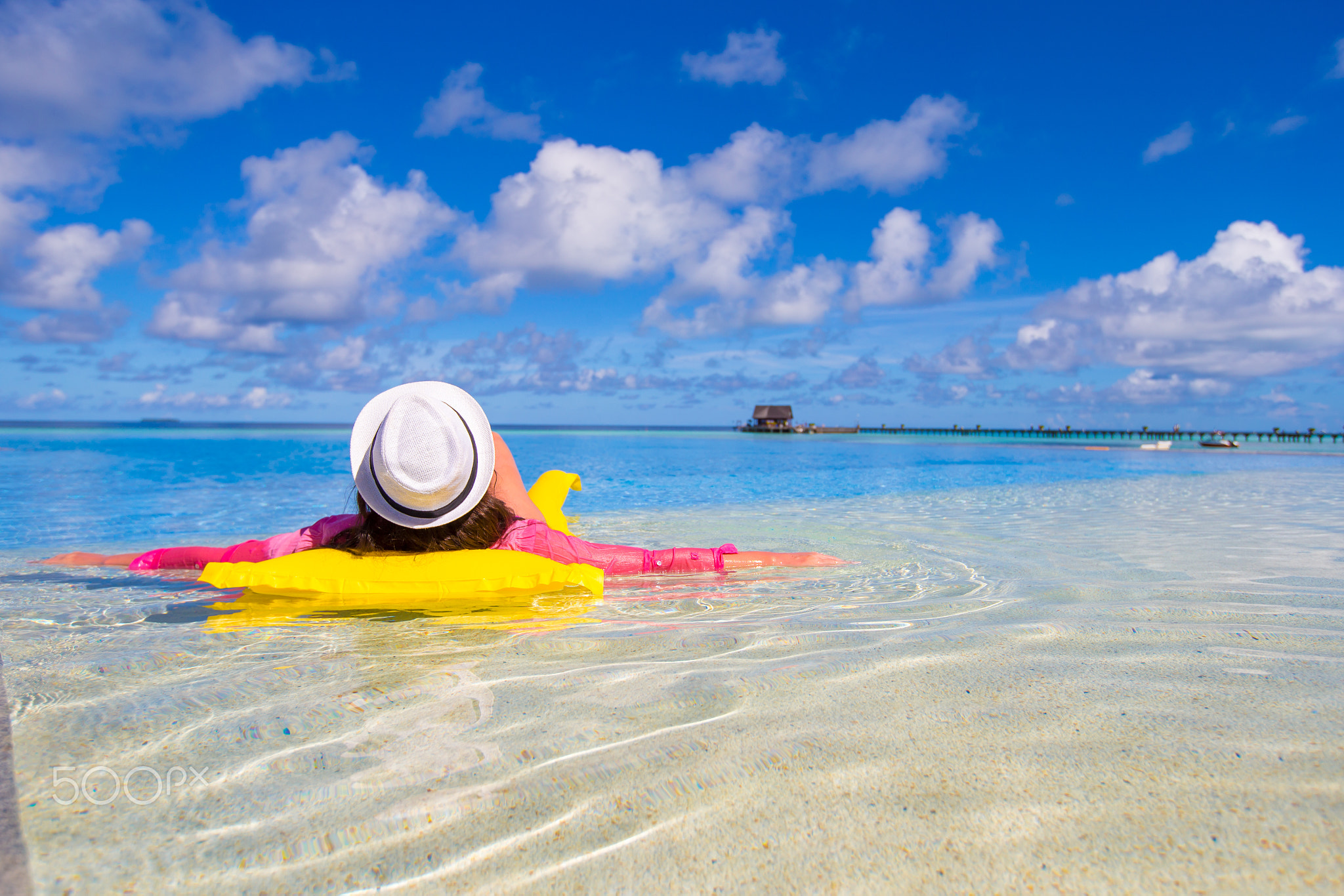 Young happy woman relaxing with air mattress in swimming pool