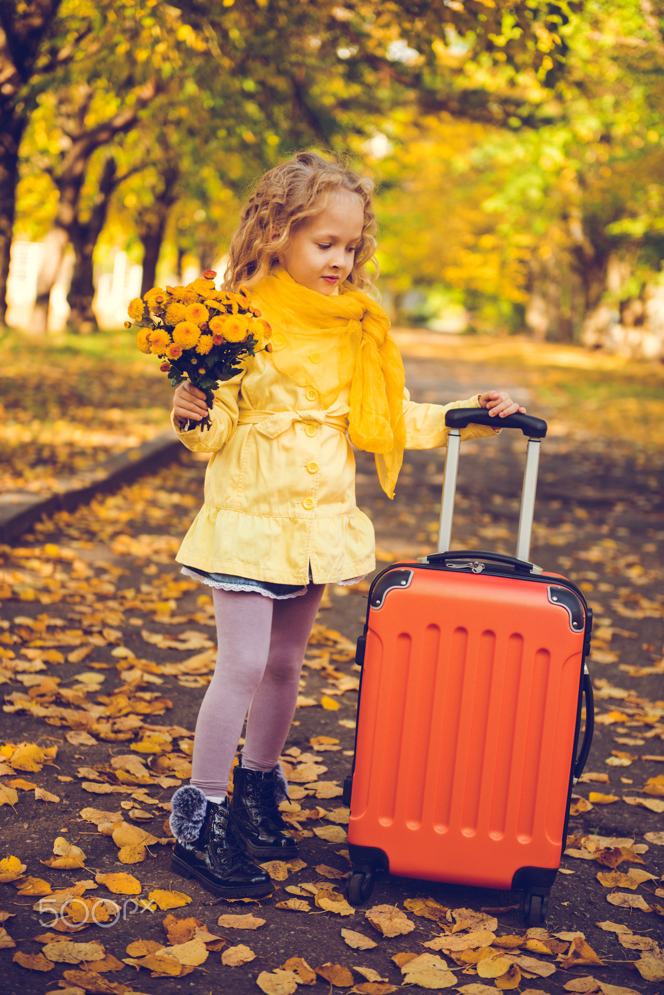 Little girl with blond hair in autumn background