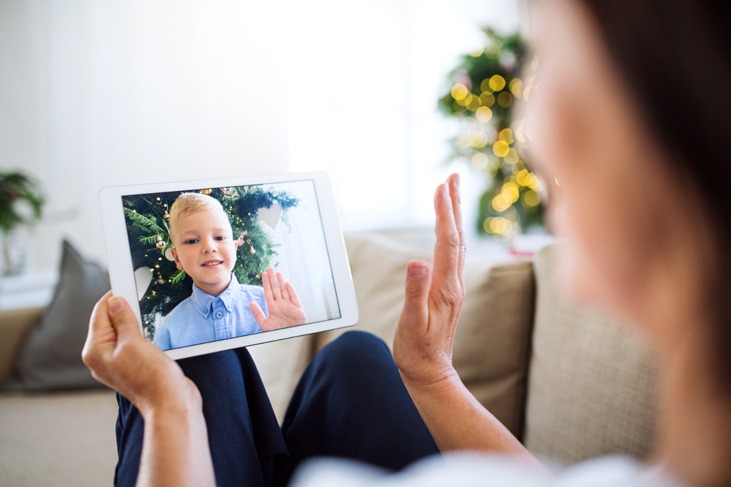 A grandmother with tablet making videocall with small grandson at Christmas time. by Jozef Polc on 500px.com