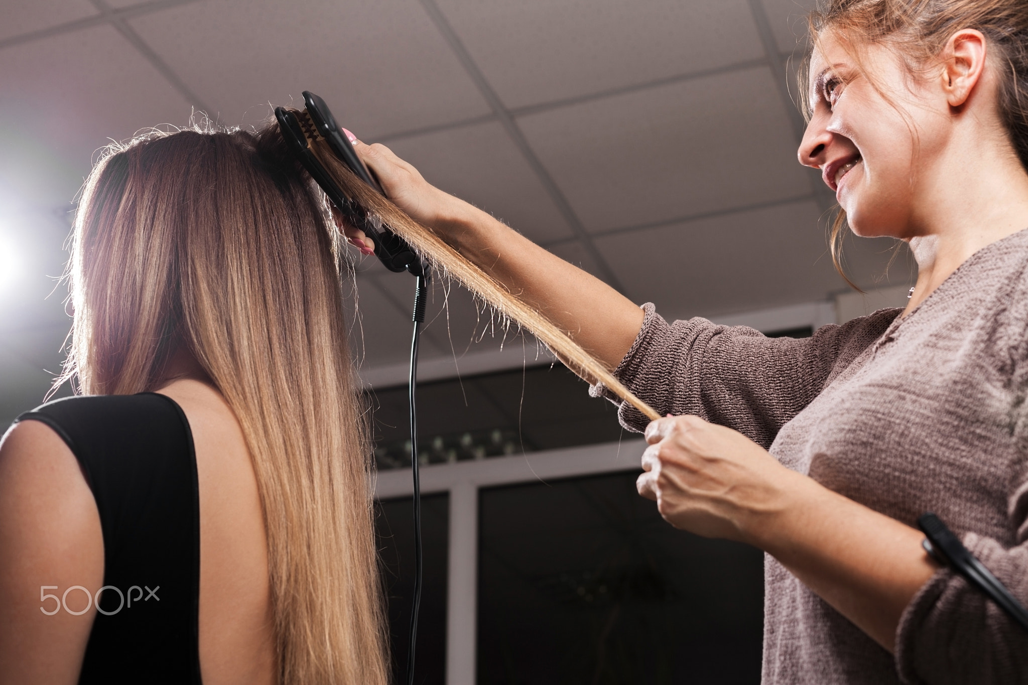 hairdresser making a gauffer hairdo of a girl