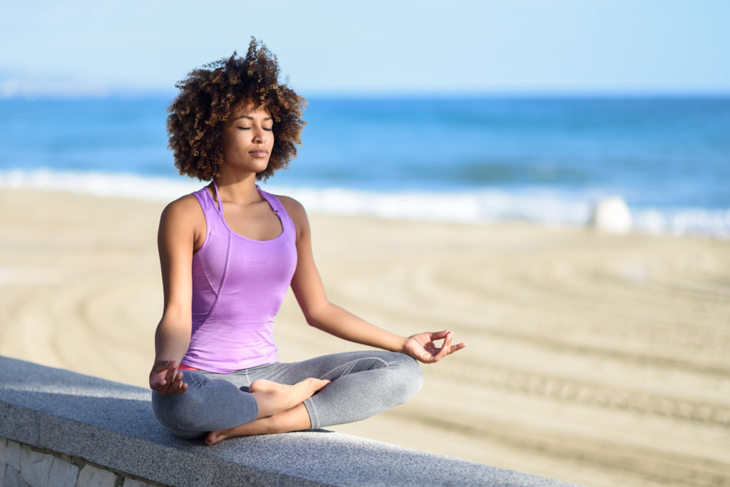 Black woman, afro hairstyle, in lotus pose with eyes closed in t by Javier Sánchez on 500px.com