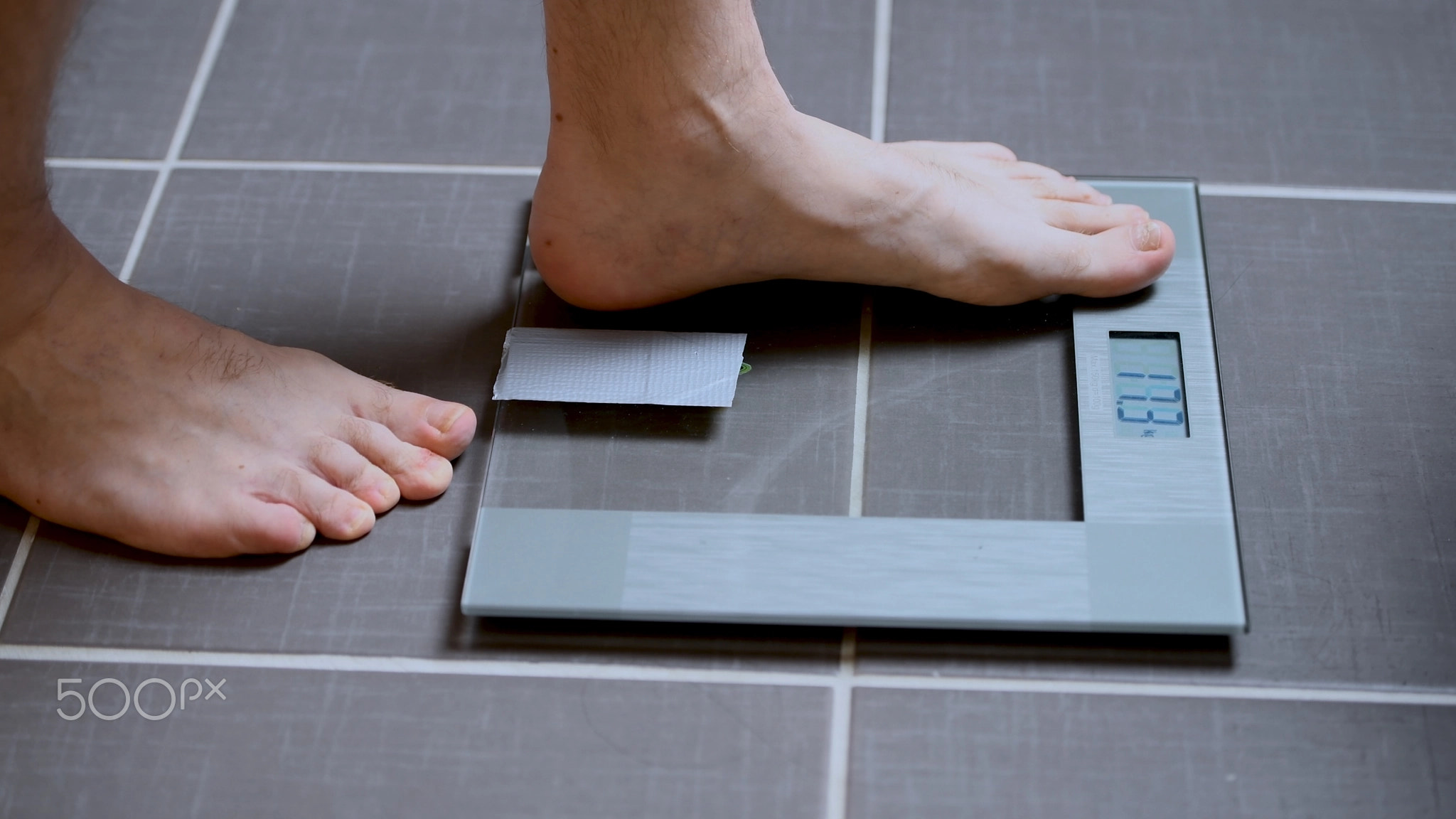 Male feet on glass scales, men's diet, body weight