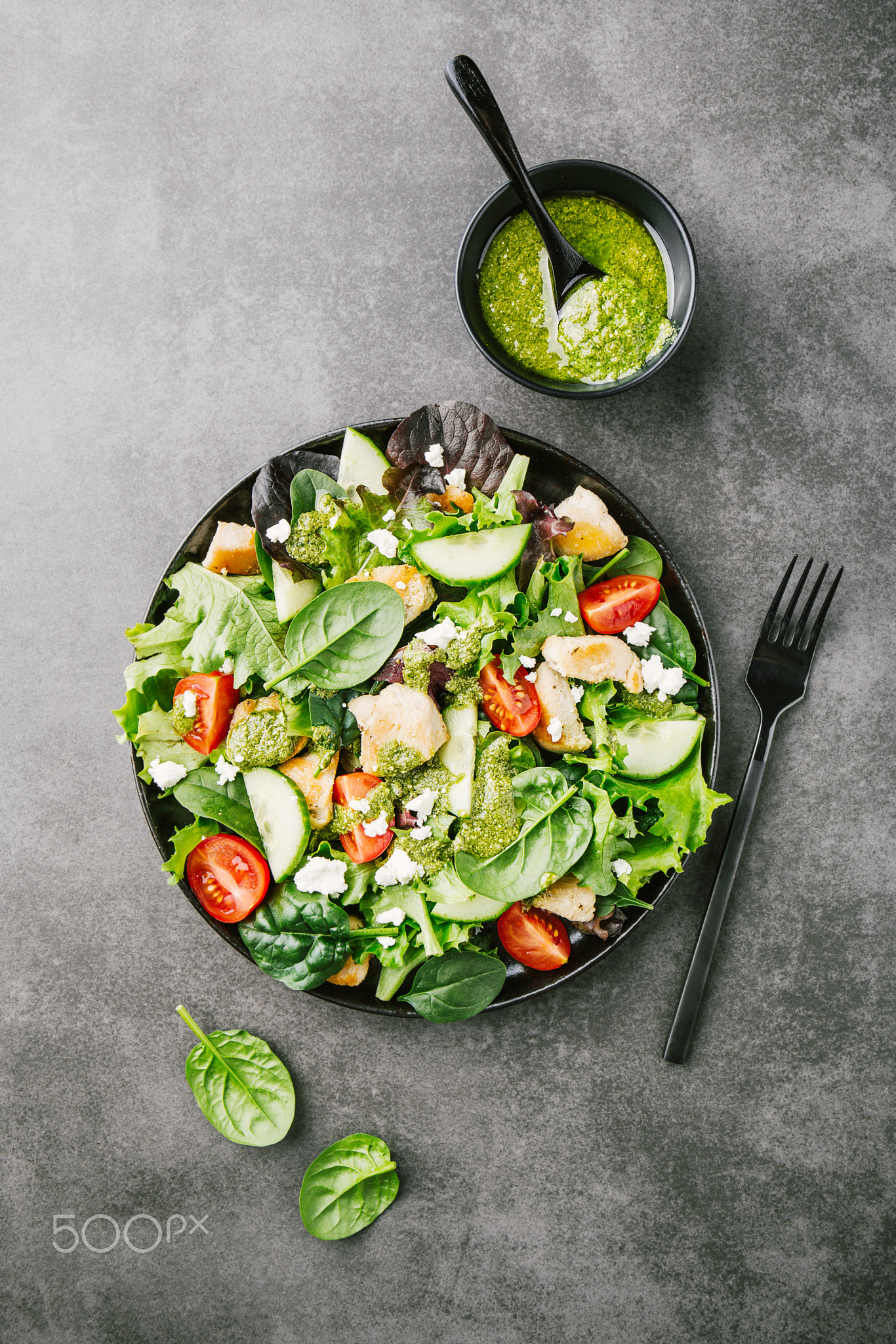 Tasty fresh salad with chicken, pesto and vegetables