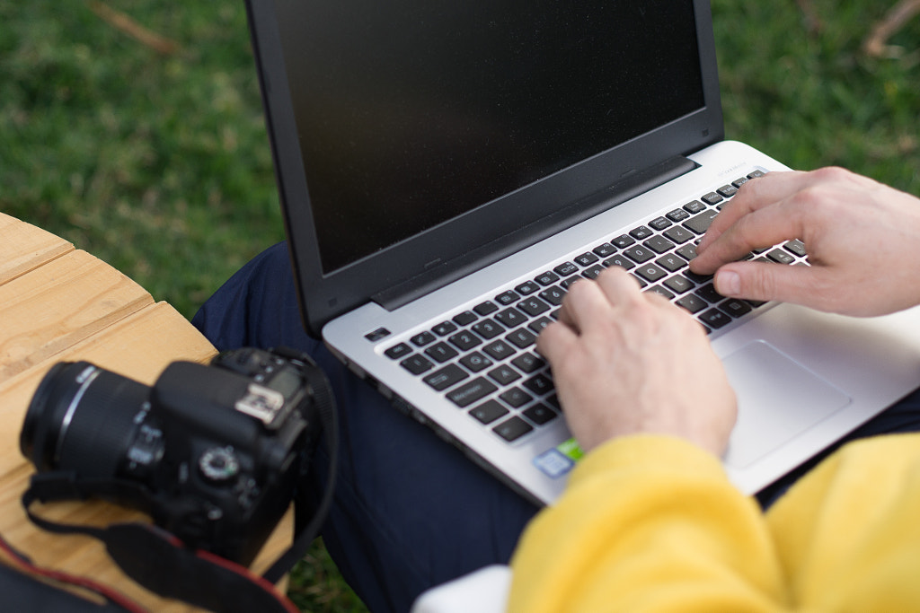 Focused man with a camera in desk writing laptop by Andres Rashti on 500px.com