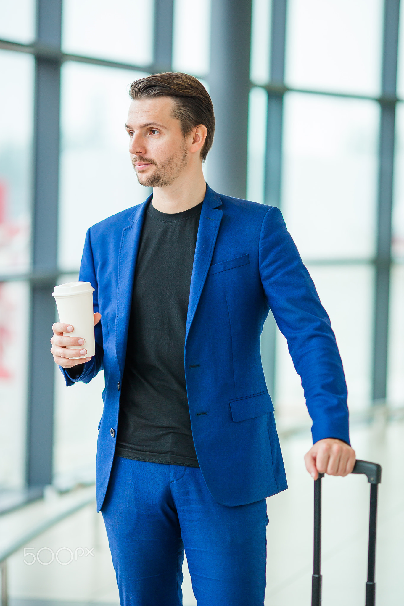 Young man in airport. Casual guy with luggage in international airport