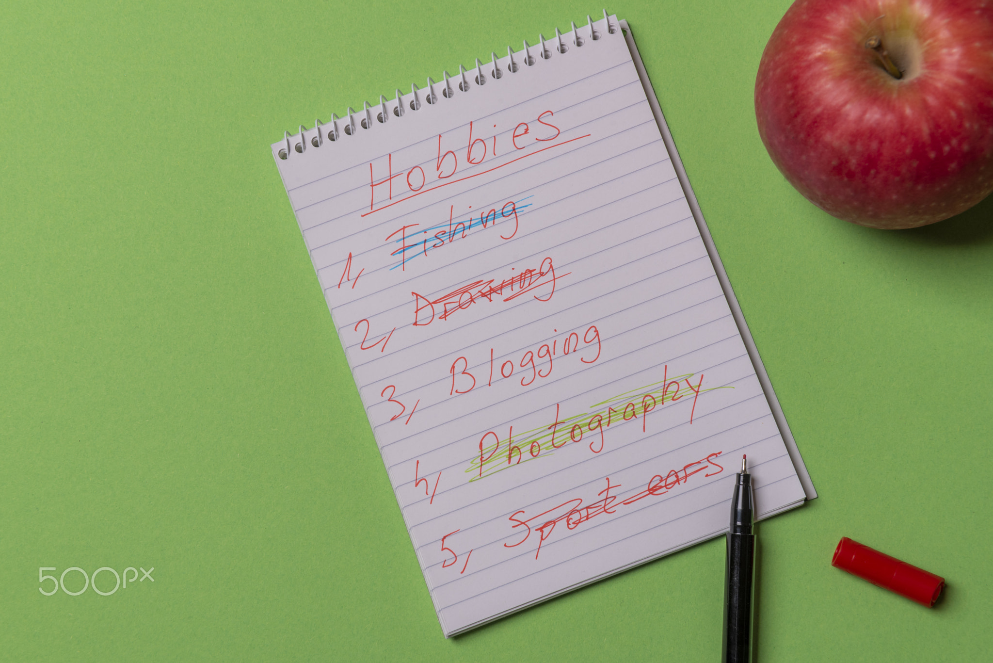 Hobbies list wrote on a spiral notebook. Above view with copy sp
