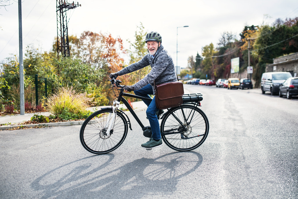 Active senior man with electrobike cycling outdoors in town. by Jozef Polc on 500px.com