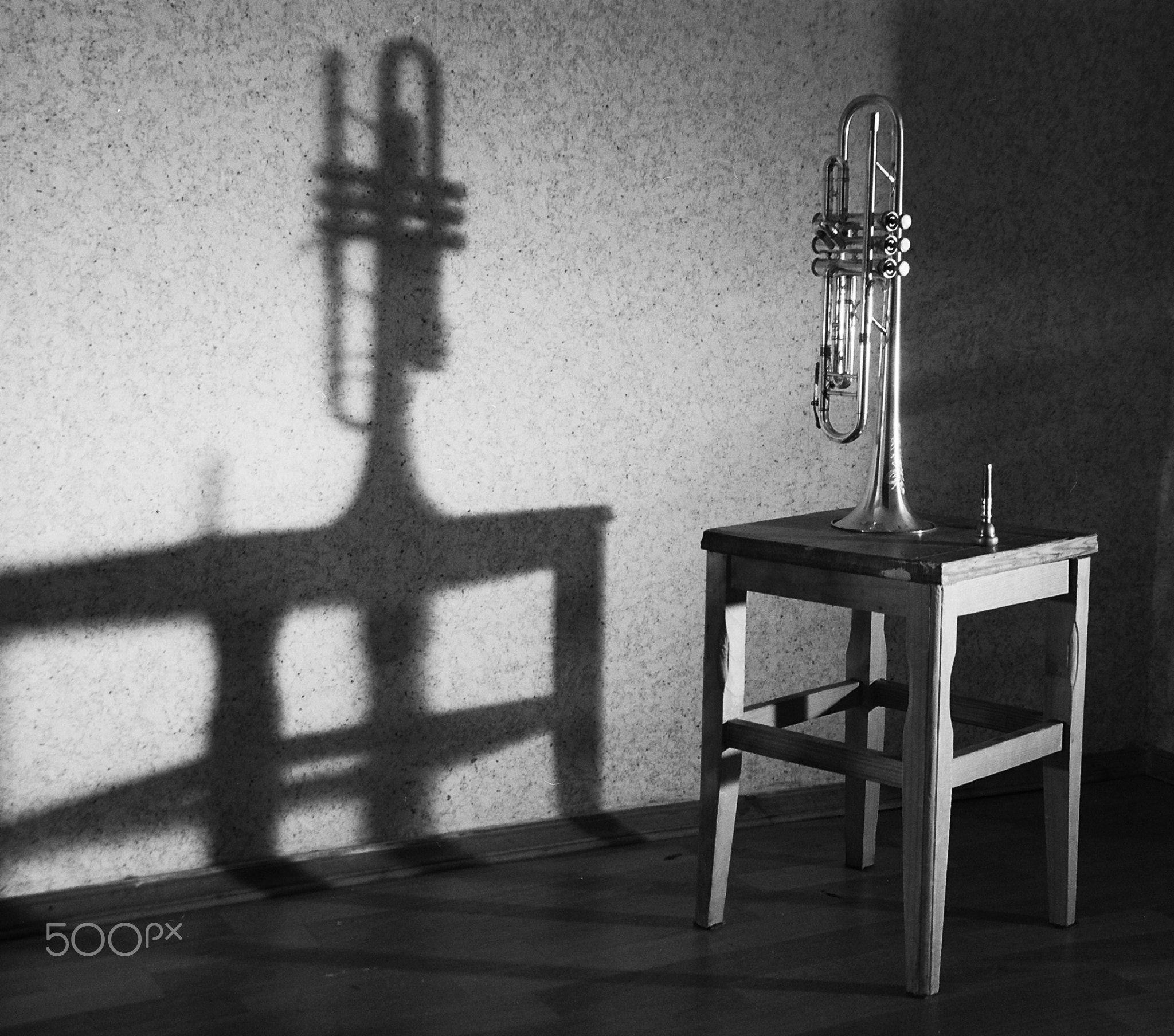 Stool with trumpet casting shadow.