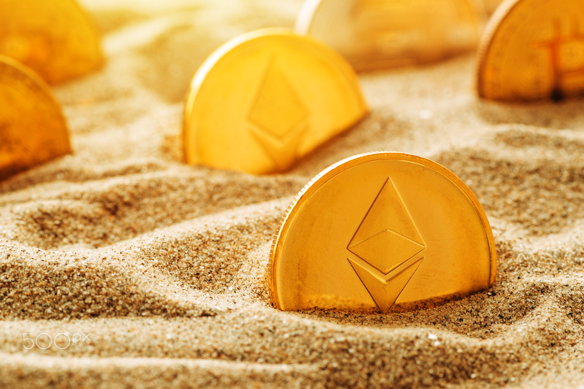 Golden Ethereum coin in sand