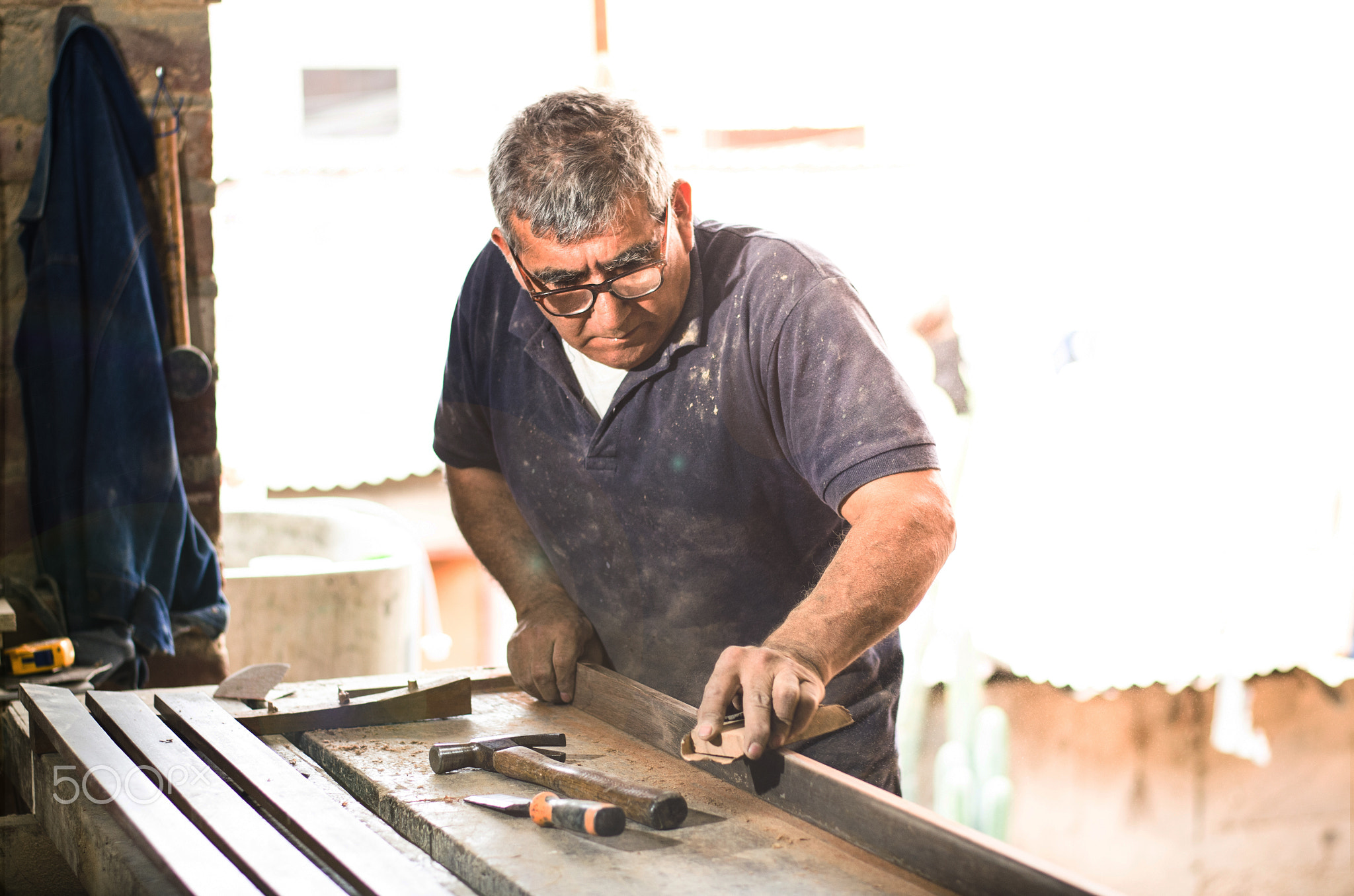 Professional carpenter sanding and refinishing wood surface.