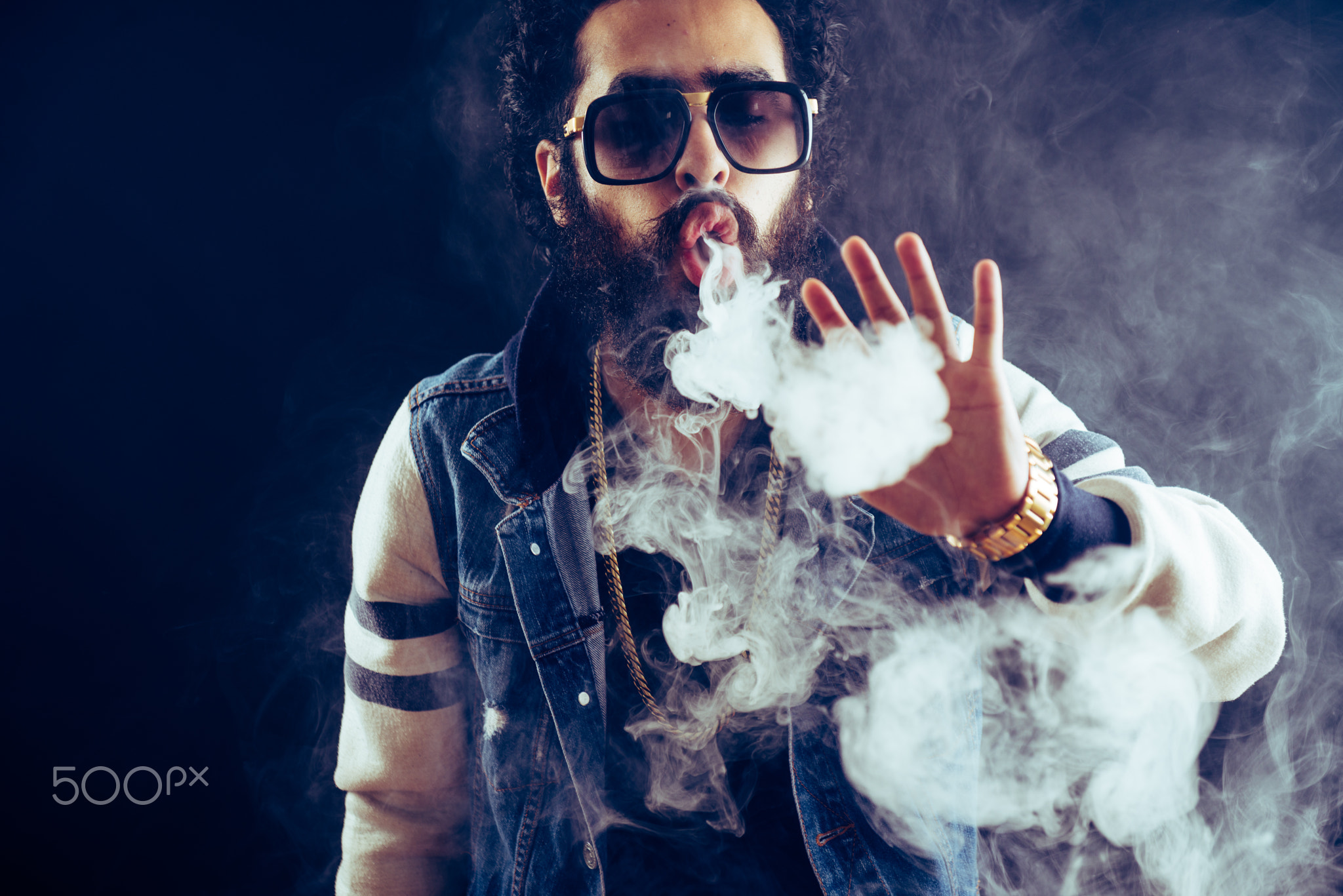 Smoking vape. vaping man holding a mod. Vape Rings. A man launches a ring of smoke.