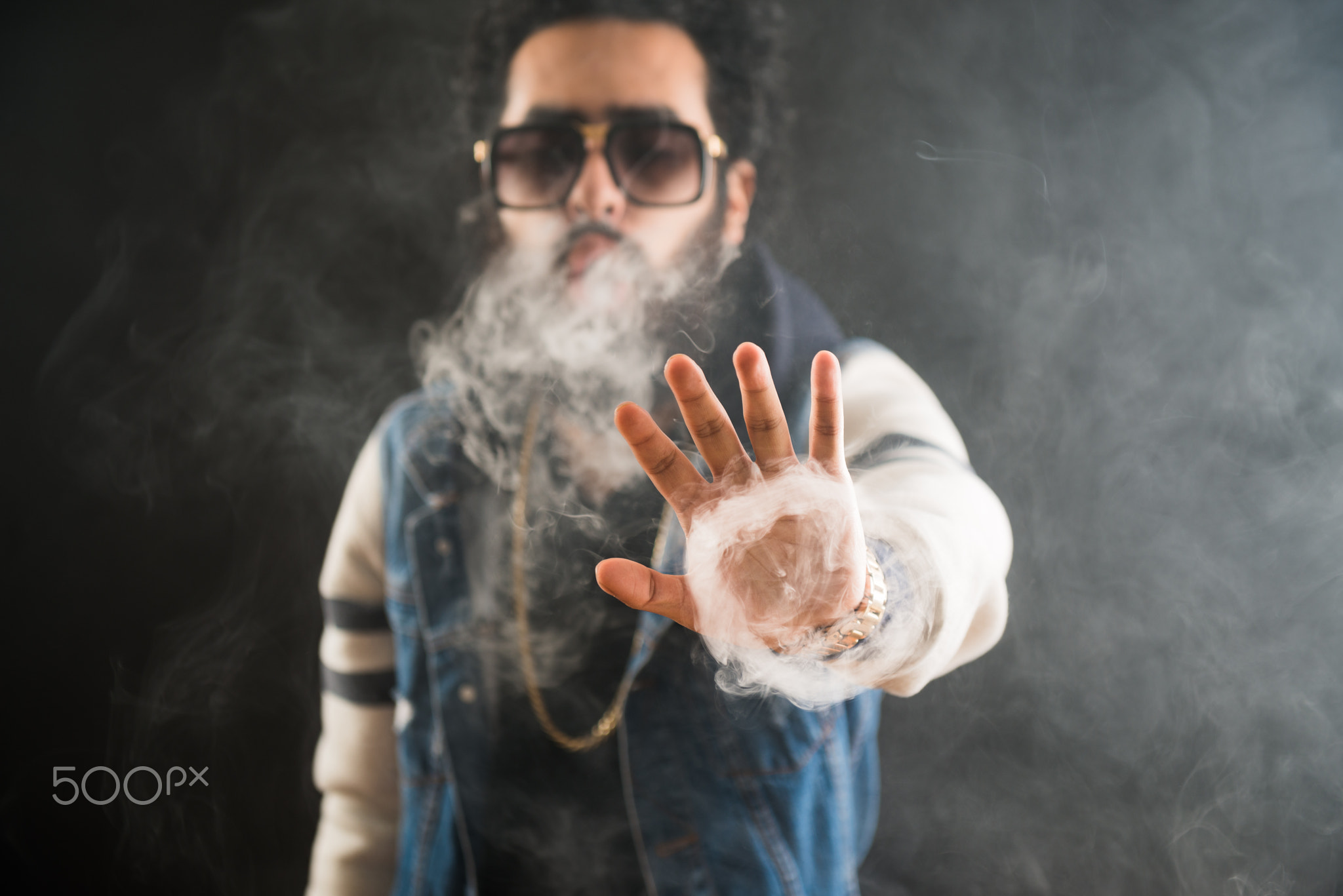 Smoking vape. vaping man holding a mod. Vape Rings. A man launches a ring of smoke.