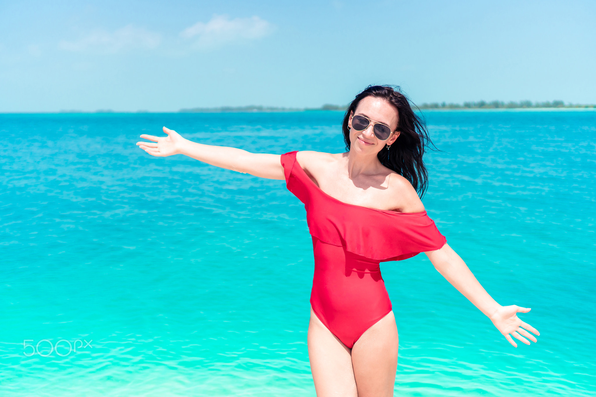 Young woman on a tropical beach with hat