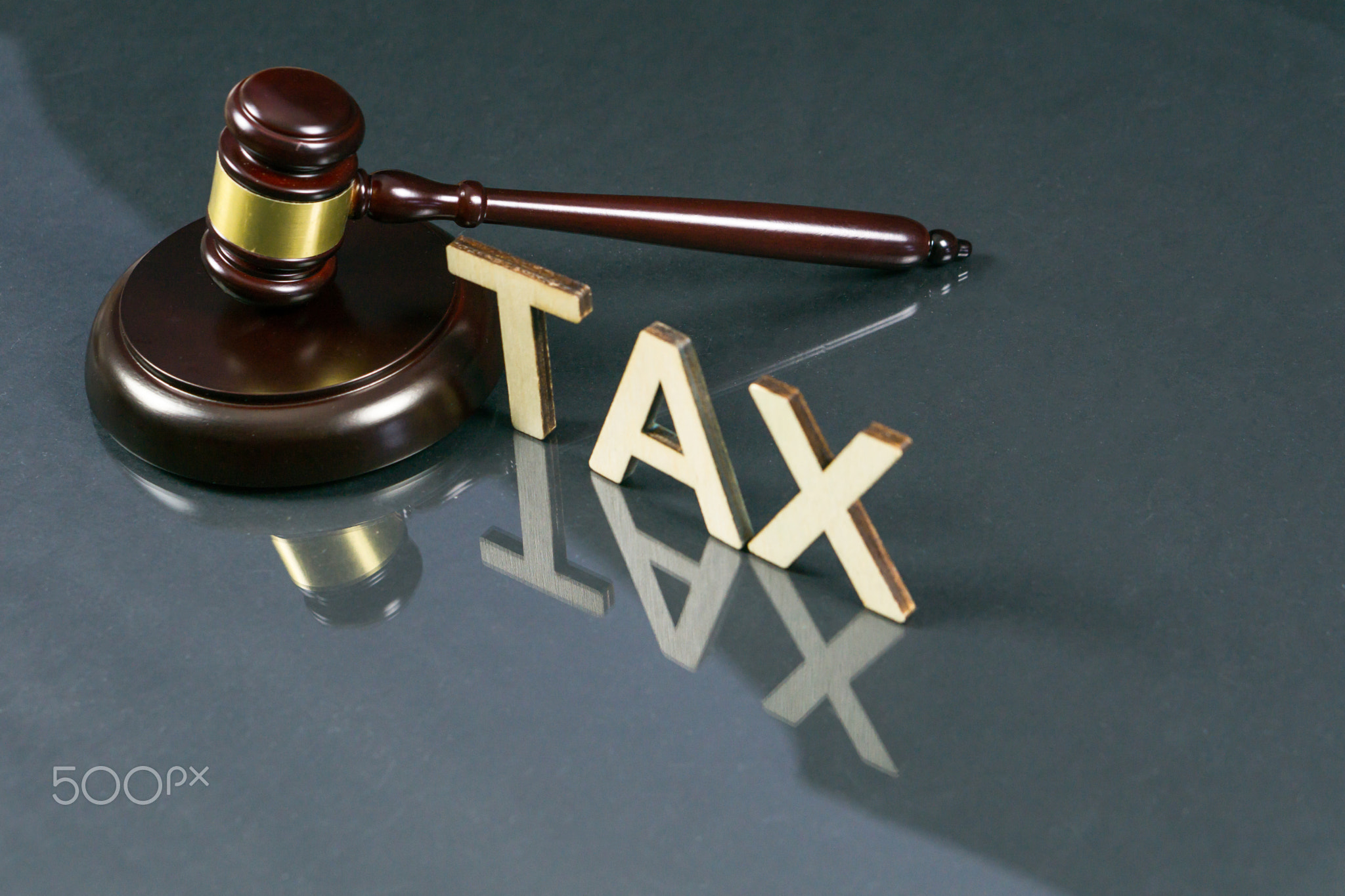 Tax law concept. Word TAX with gavel and money on the table.