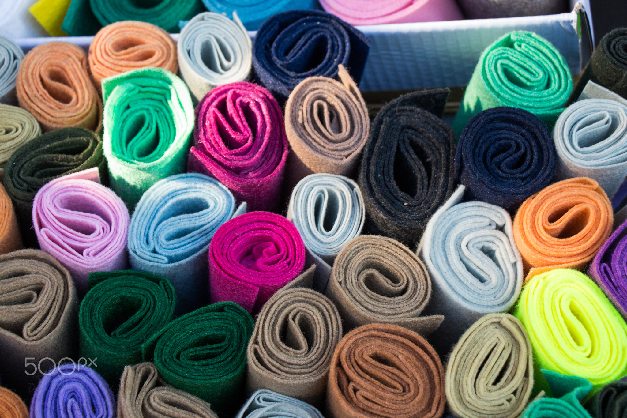 Dozens of colorful fabric rolls in display
