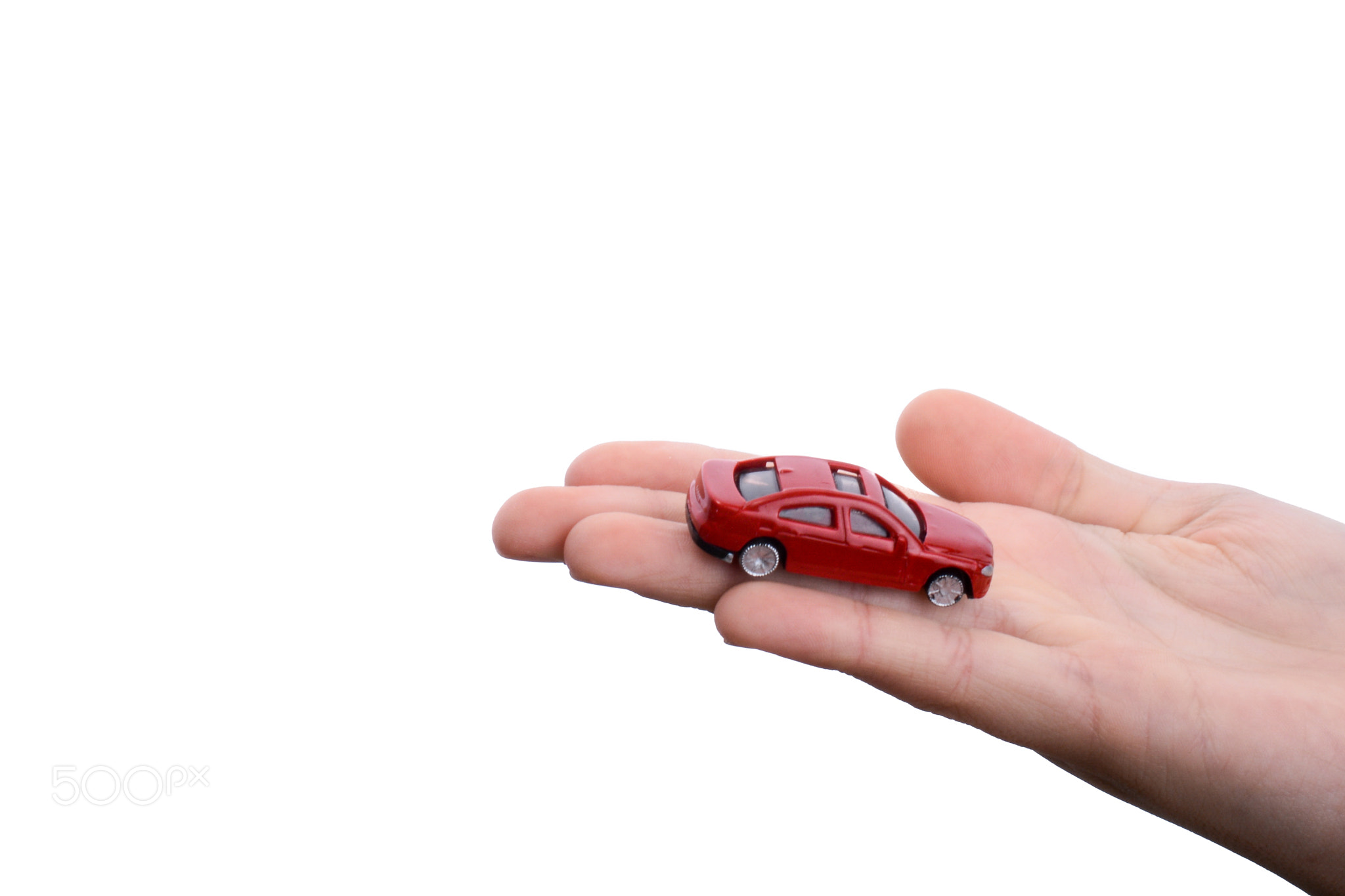 Child hand holding a red car