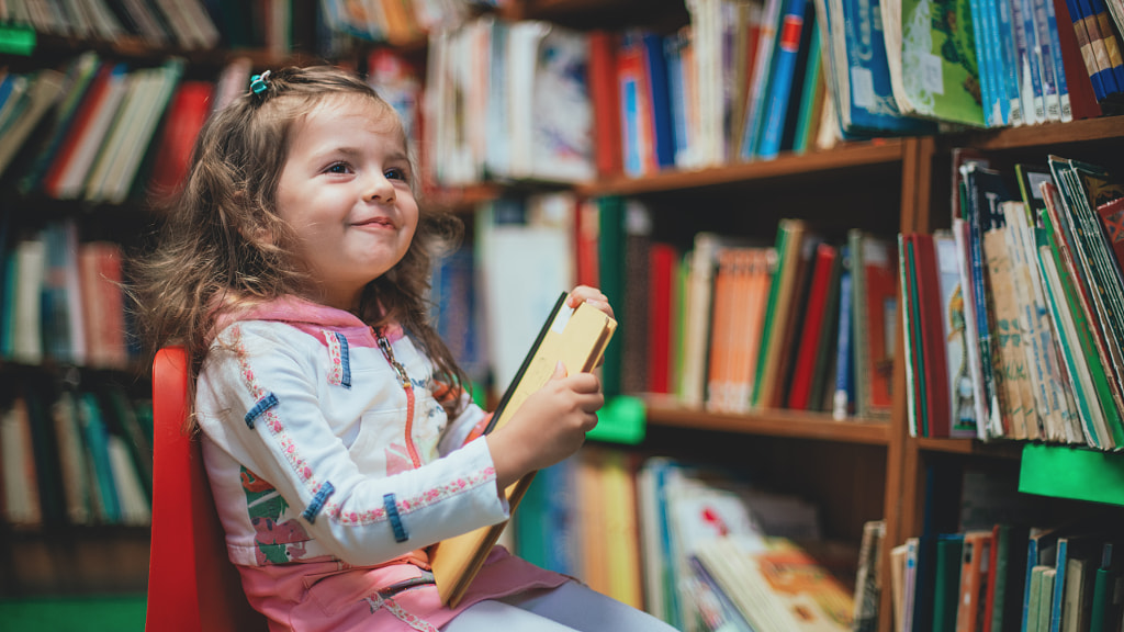 Cute girl reading book in library by Valentin Valkov on 500px.com