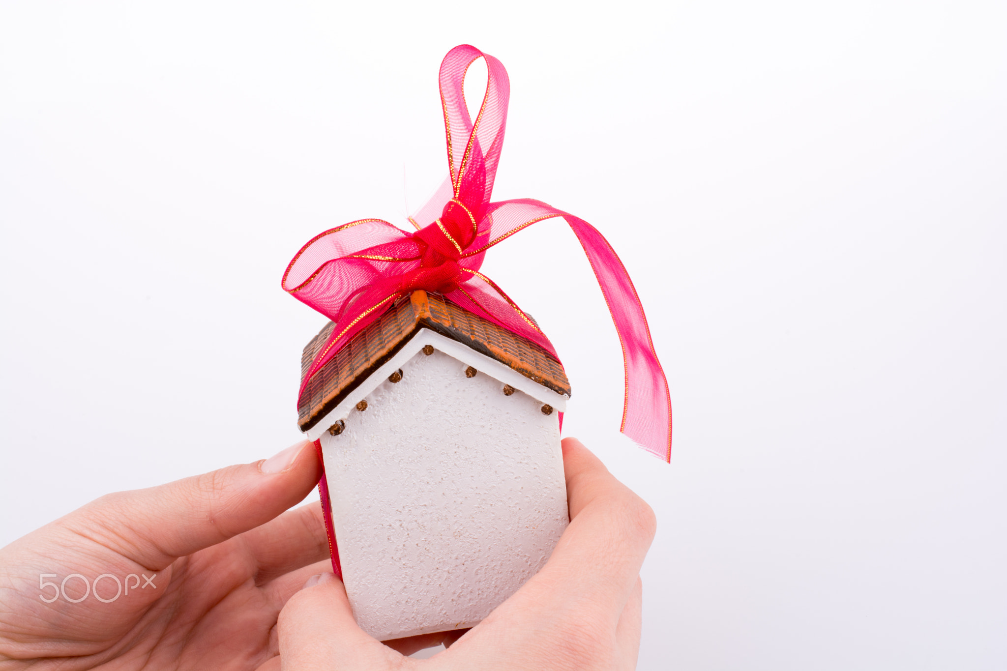 Hand holding a house with a ribbon