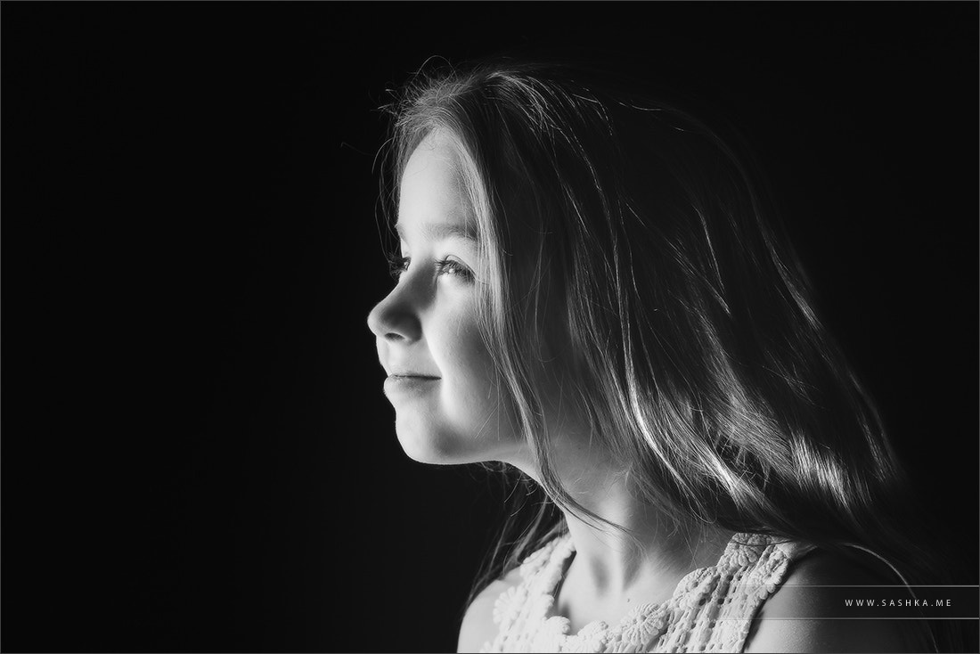 Cute little schoolgirl emotive studio portrait, isolated on blac