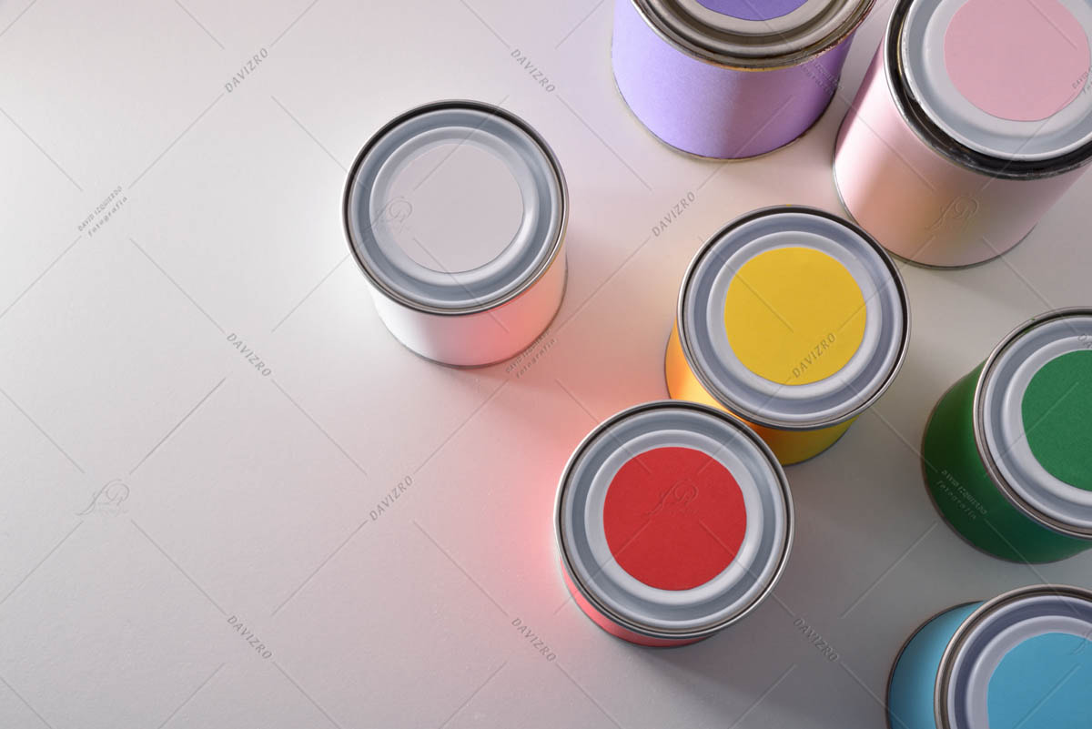 Colored paint pots on white table top view