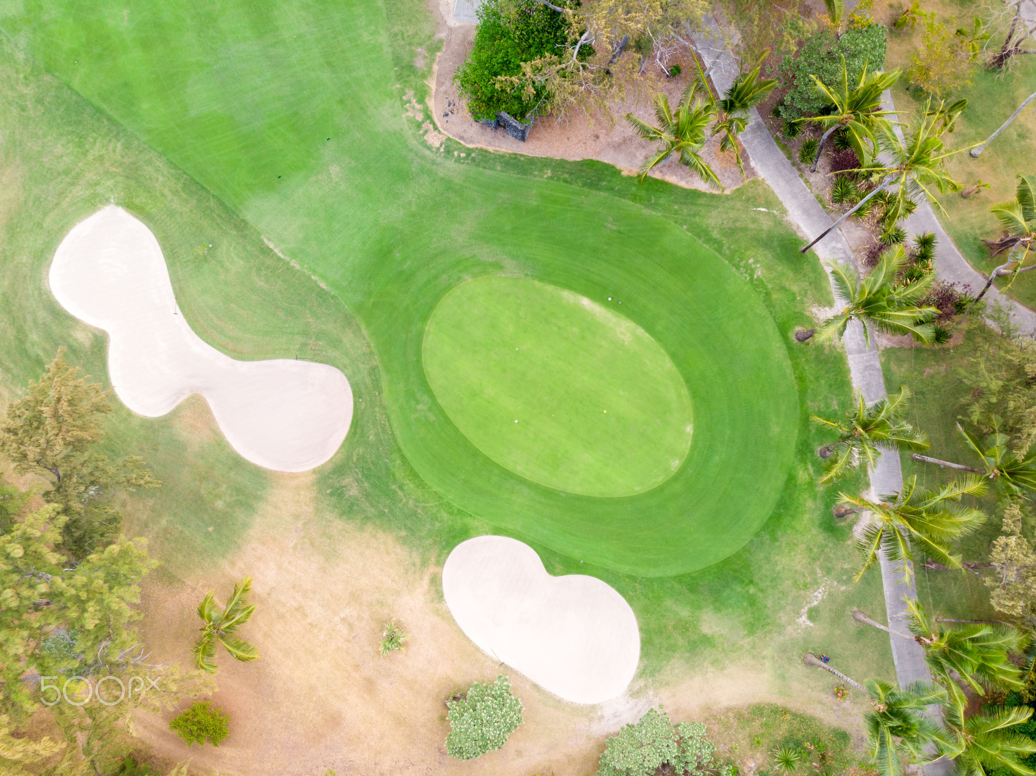 Birds eye view of golf course hole green and sand traps.