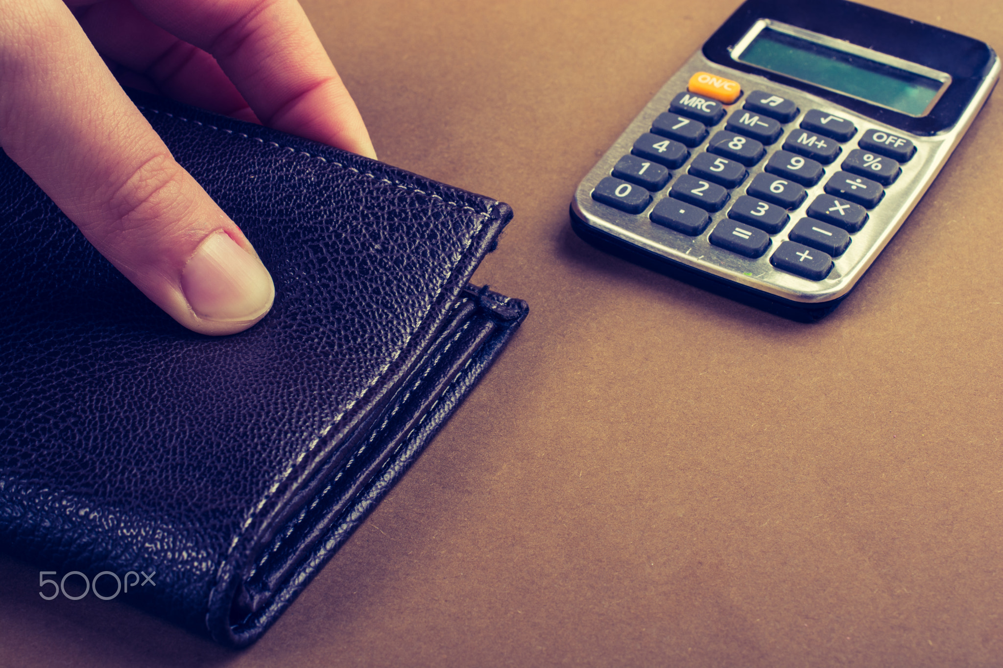 Calculator and wallet in hand as finance concept