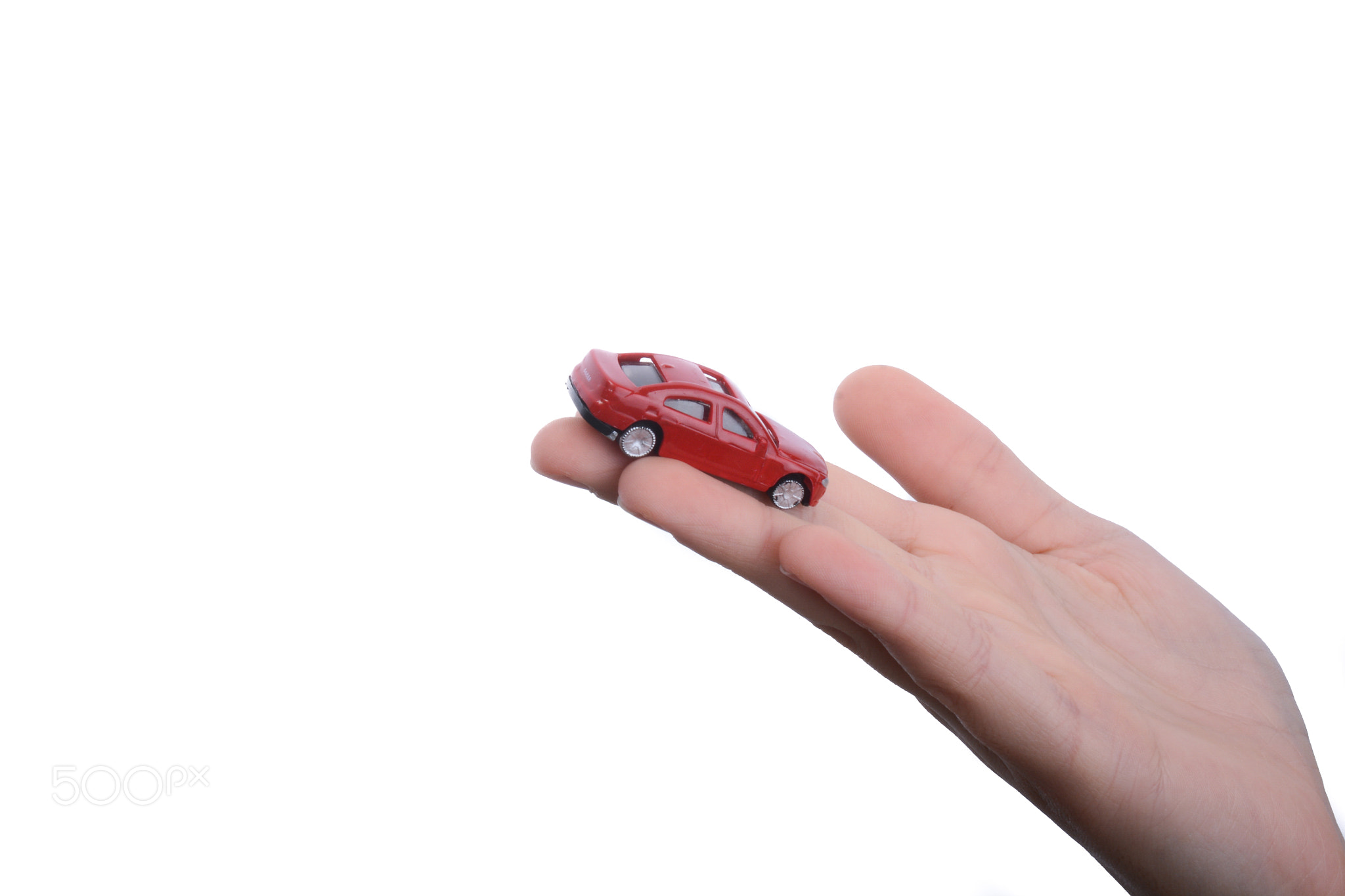 Child hand holding a red car
