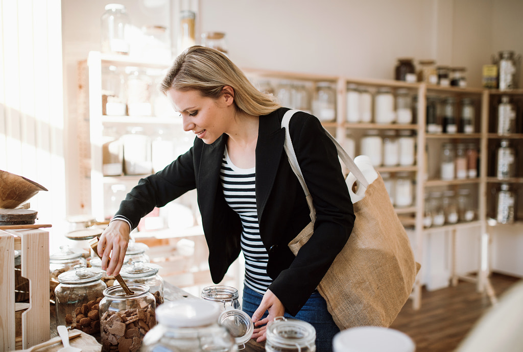 A young happy woman buying groceries in zero waste shop. by Jozef Polc on 500px.com