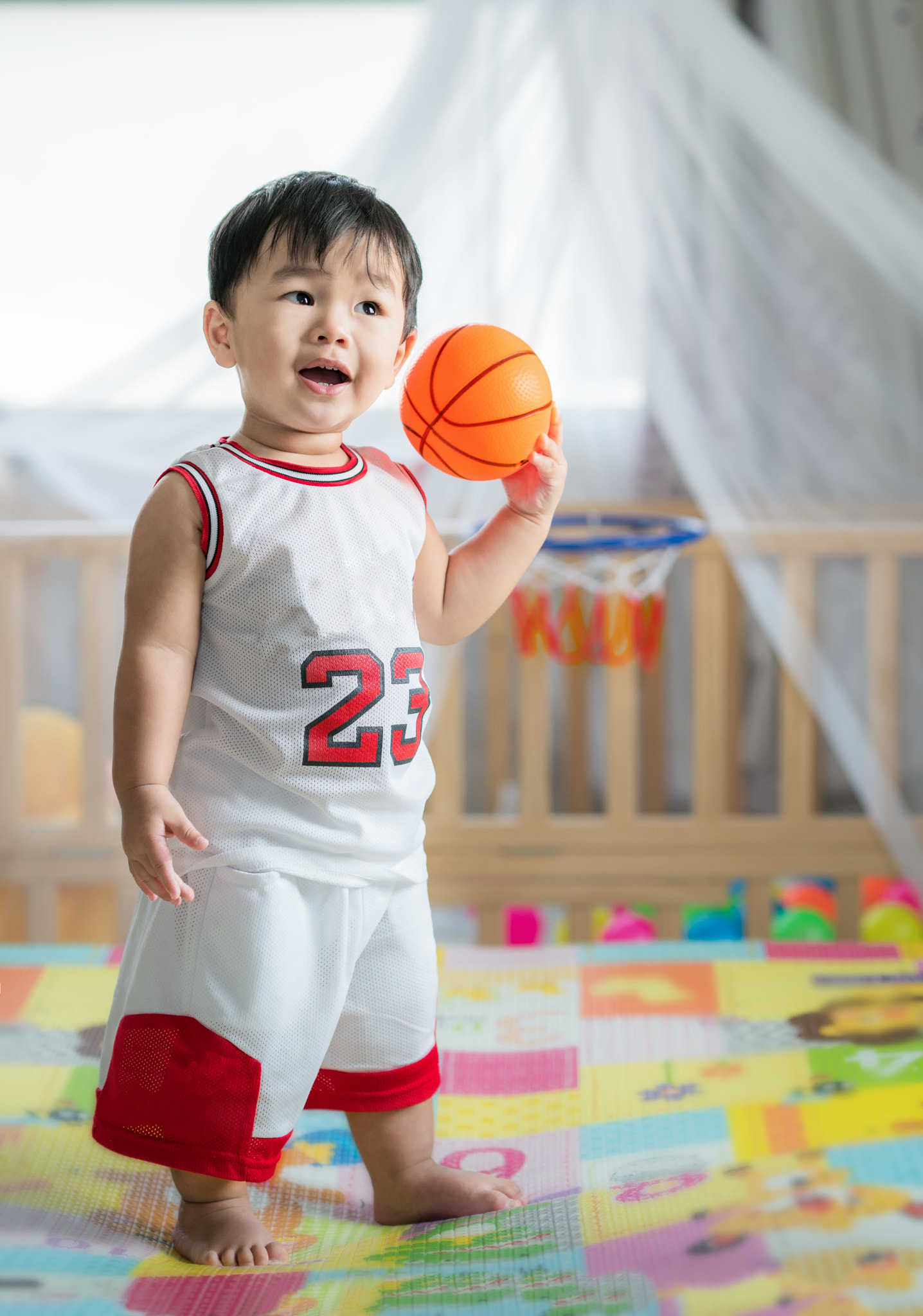Baby with ball in basketball uniform