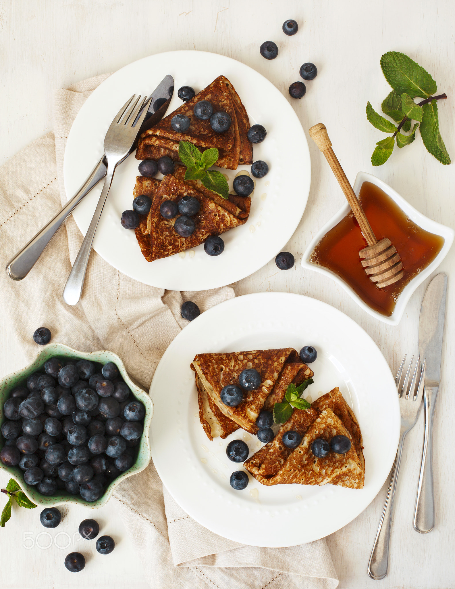 Homemade crepes with fresh blueberries and honey