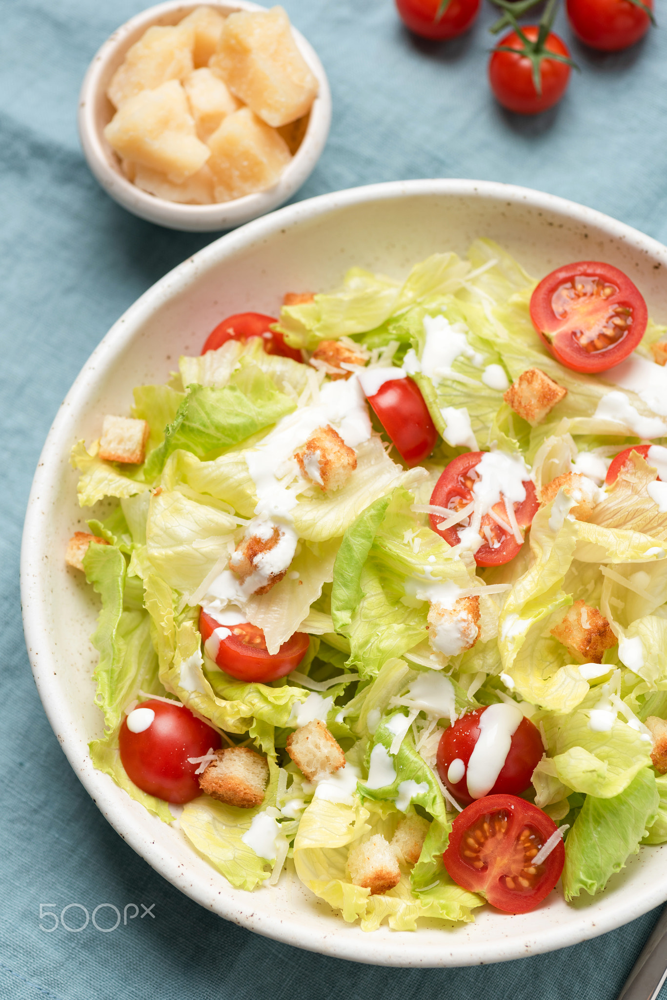 Caesar salad with sauce on plate, top view