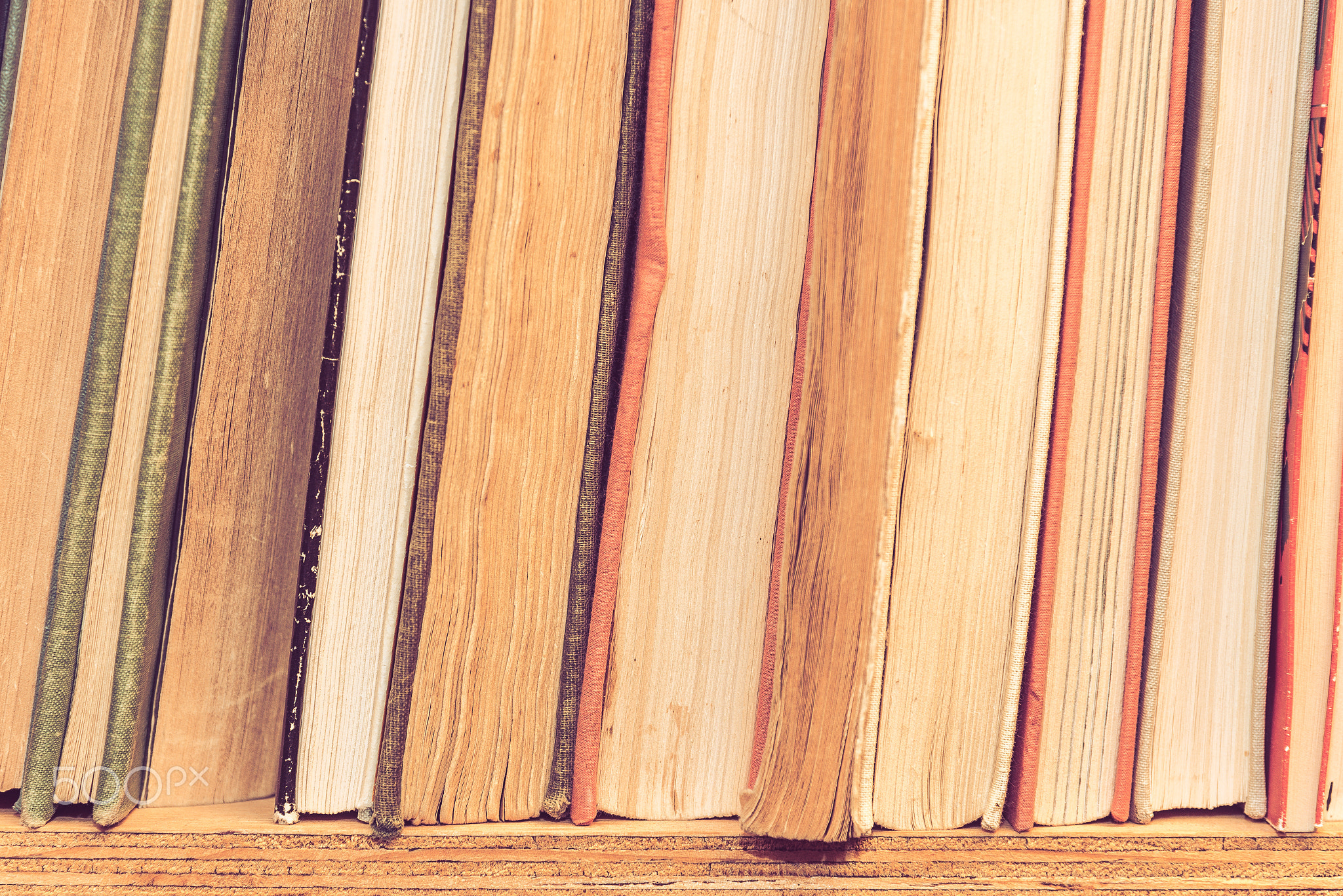 Stack of many old books on shelf in book store.