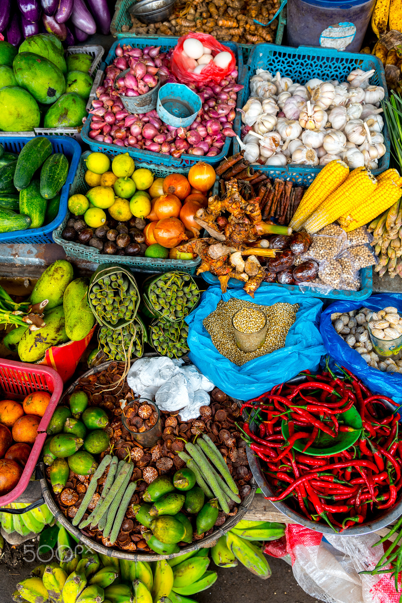 Fresh fruits and vegetables are displayed in a traditional market in Asia.