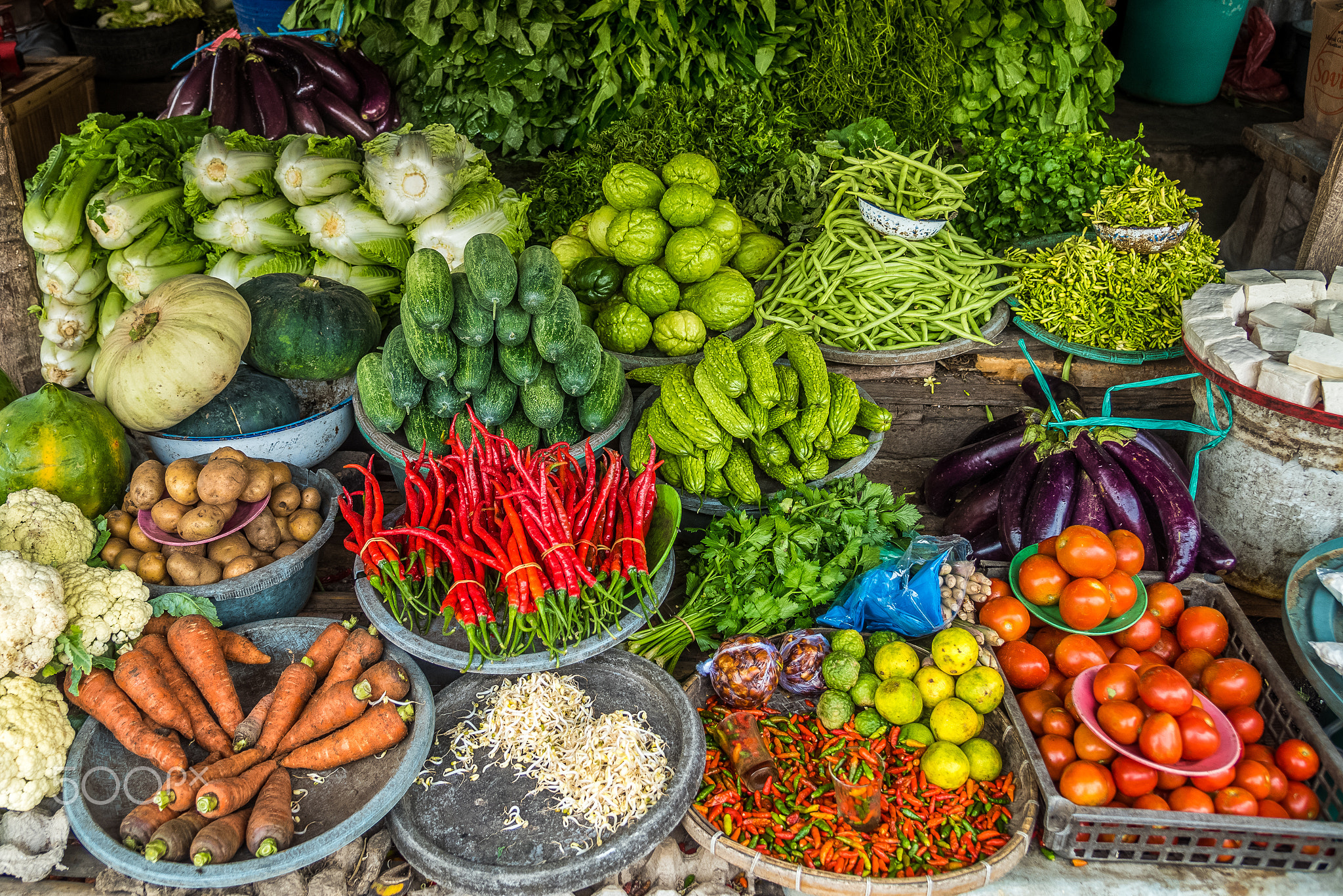 Fresh fruits and vegetables are displayed in a traditional market in Asia.