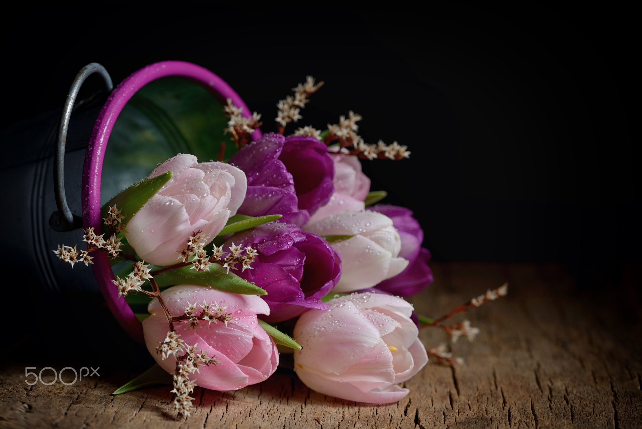 Tulips in a bucket on a wooden table