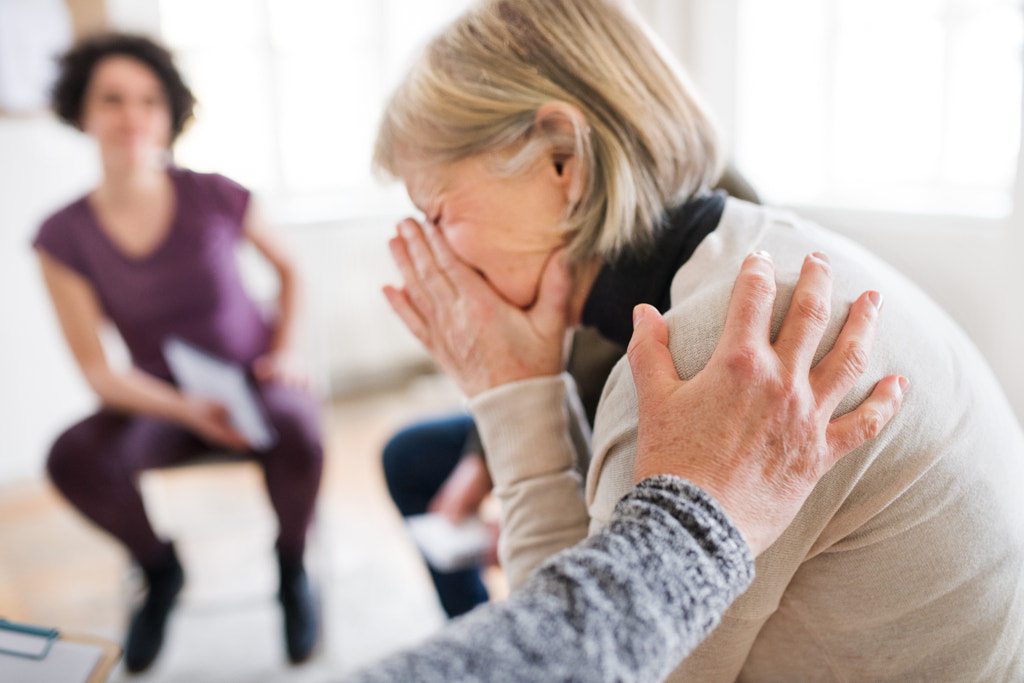 A senior depressed woman crying during group therapy. by Jozef Polc on 500px.com