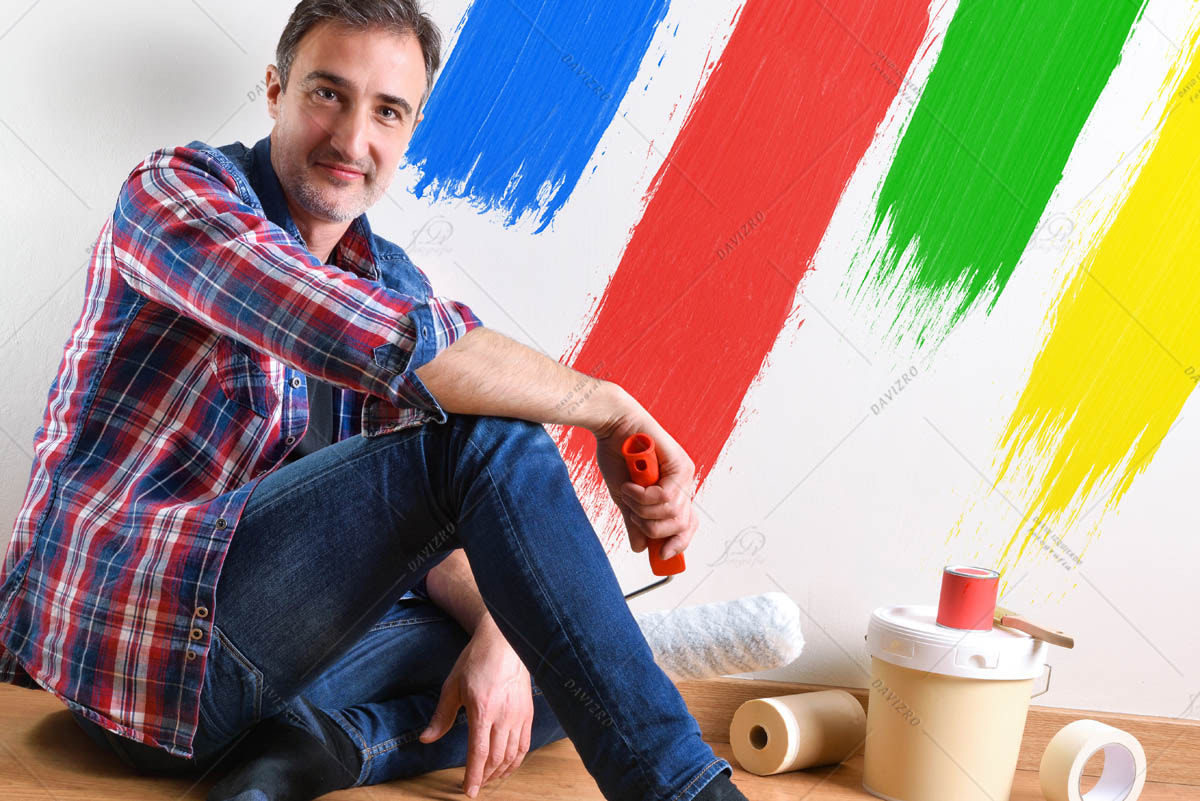 Man sitting on parquet and wall painted with colors detail