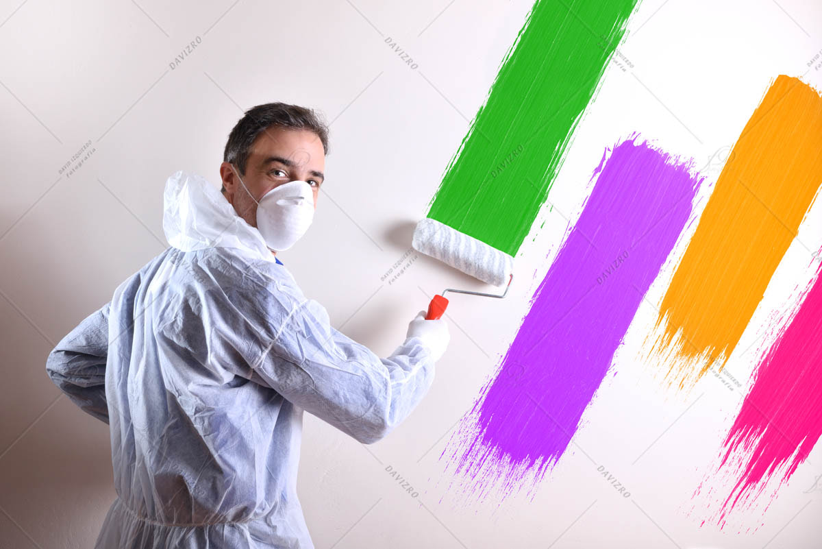 Painter turning with overals and wall painted with four colors