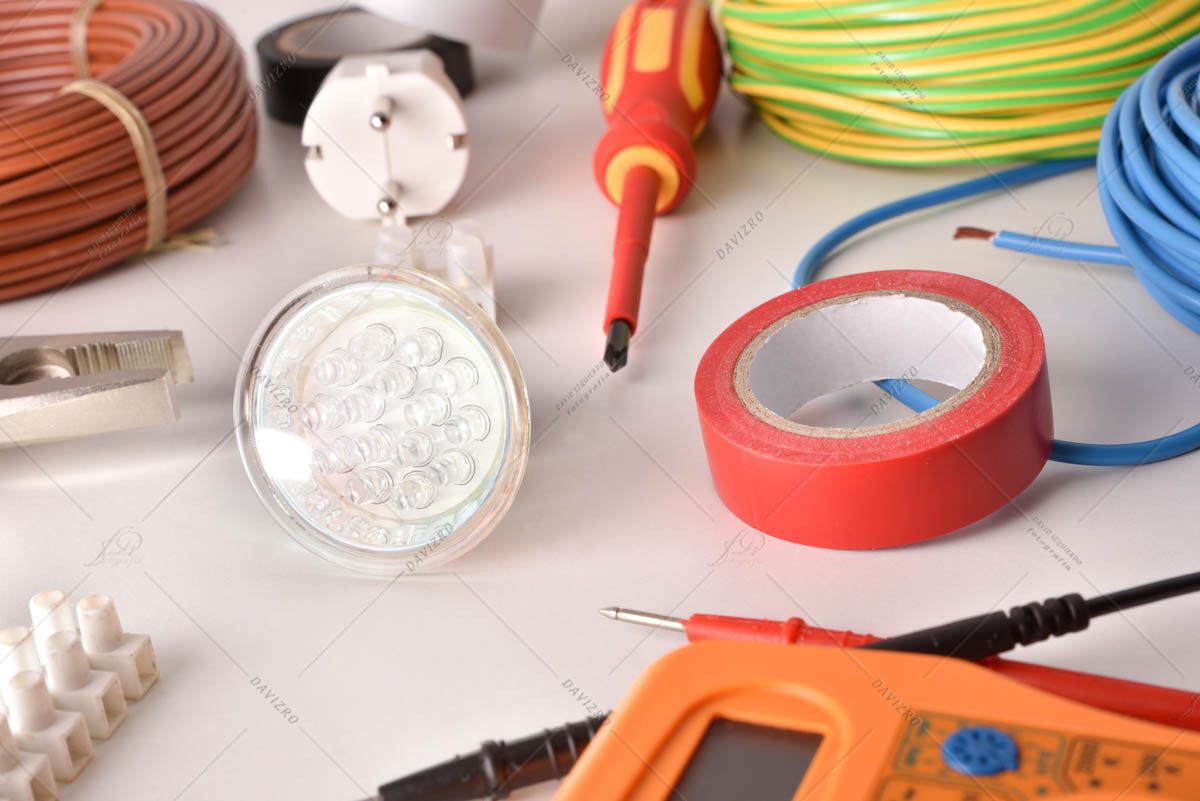 Tools and electrical material on a white table elevated view