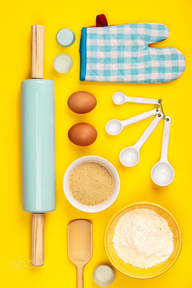Baking or cooking ingredients on yellow background, flat lay