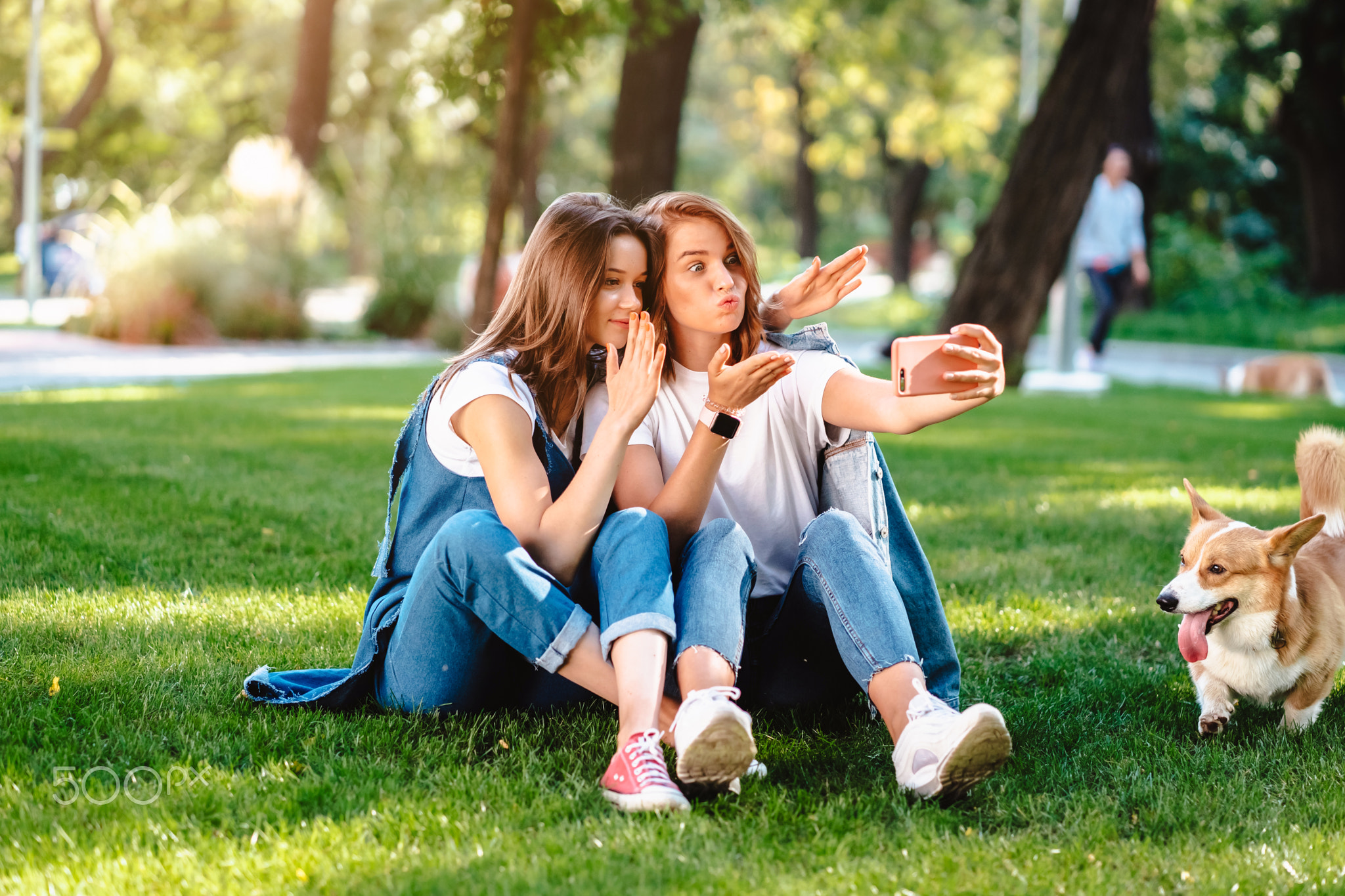 Two female friend sitting in the park have a rest take a selfie