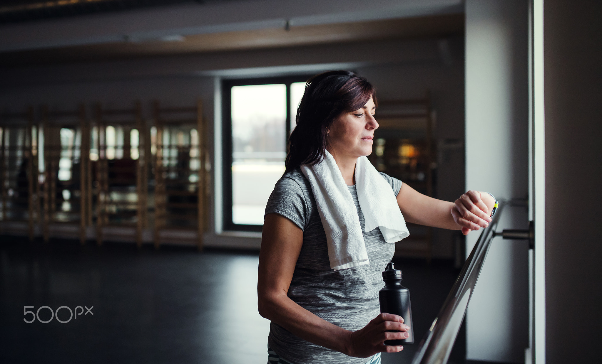 A senior woman in gym resting after doing exercise. Copy space.